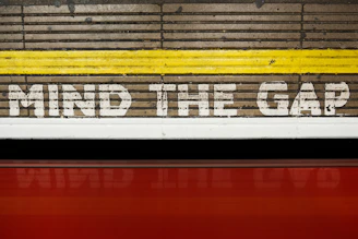 A sign that says mind the gap on the side of a train