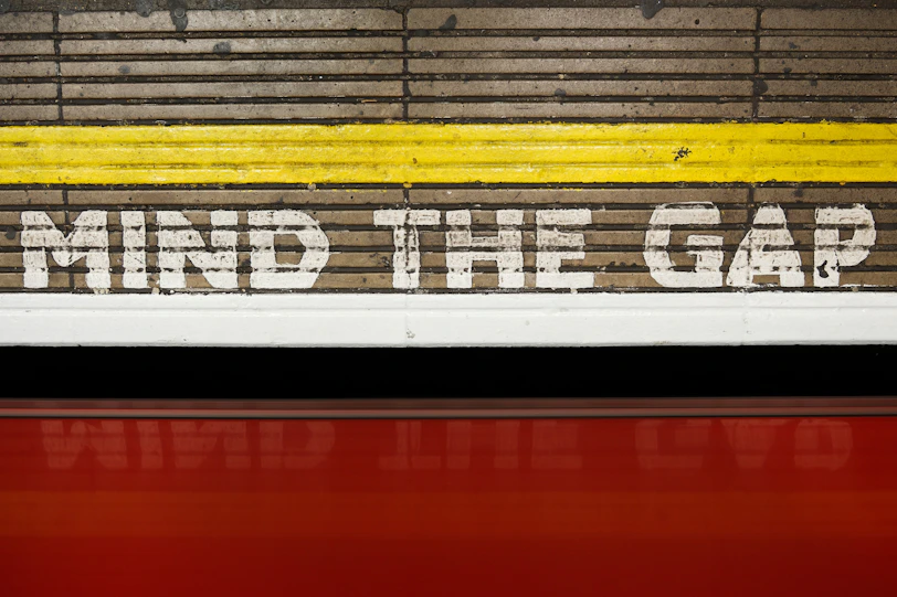 A sign that says mind the gap on the side of a train