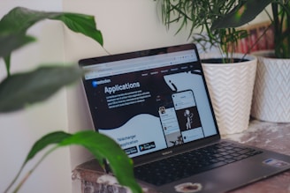 A laptop computer sitting on top of a wooden desk
