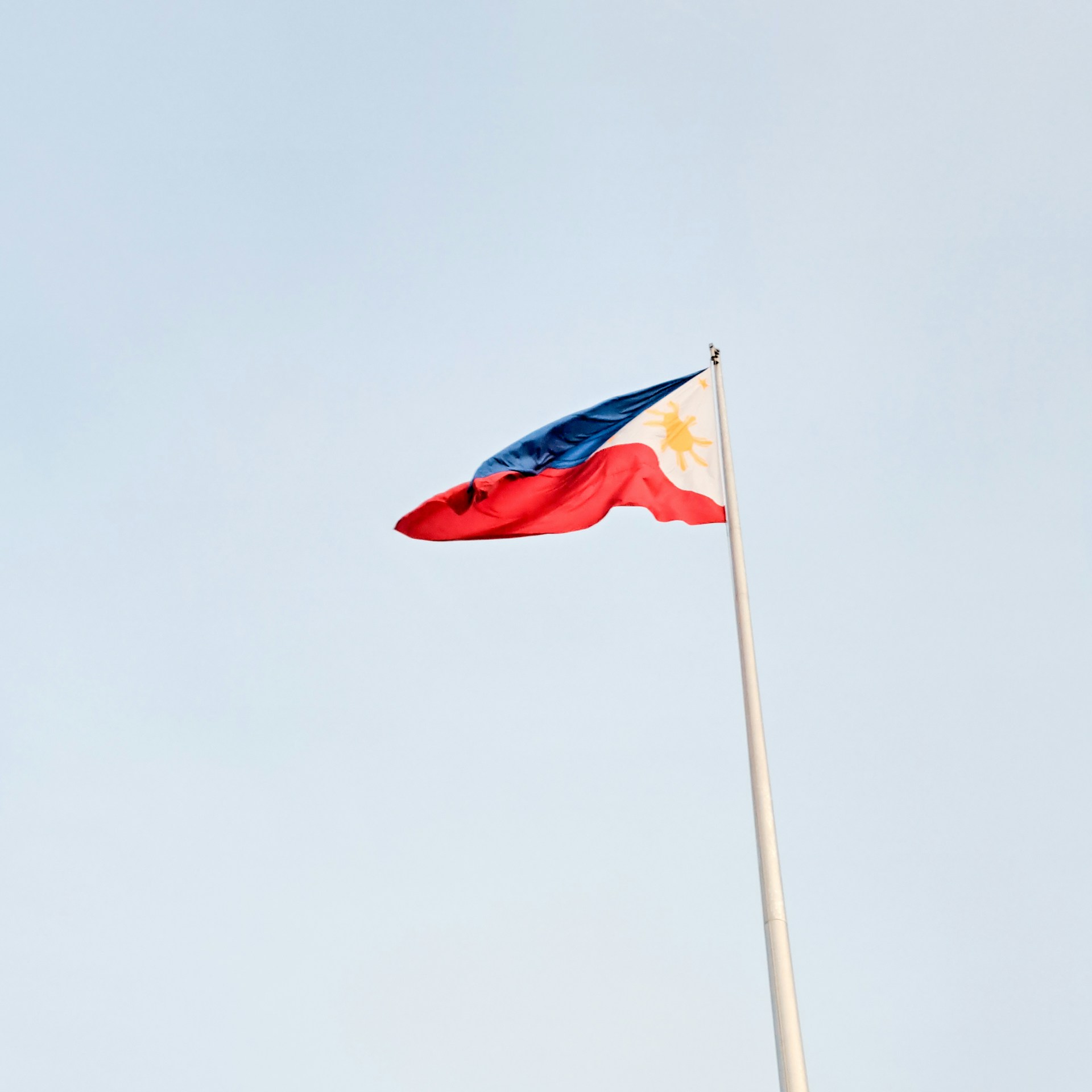 The flag of the philippines flies high in the sky