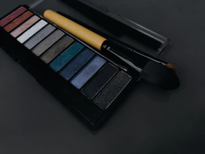 A palette of eyeshades and a brush on a table