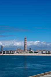 A large body of water with a lighthouse in the background