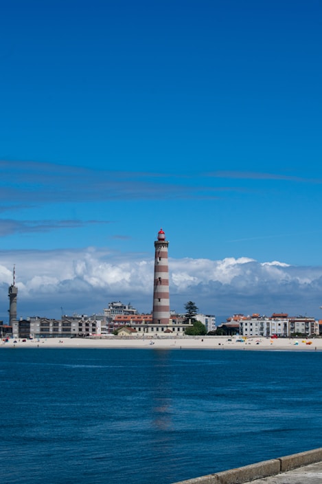 A large body of water with a lighthouse in the background