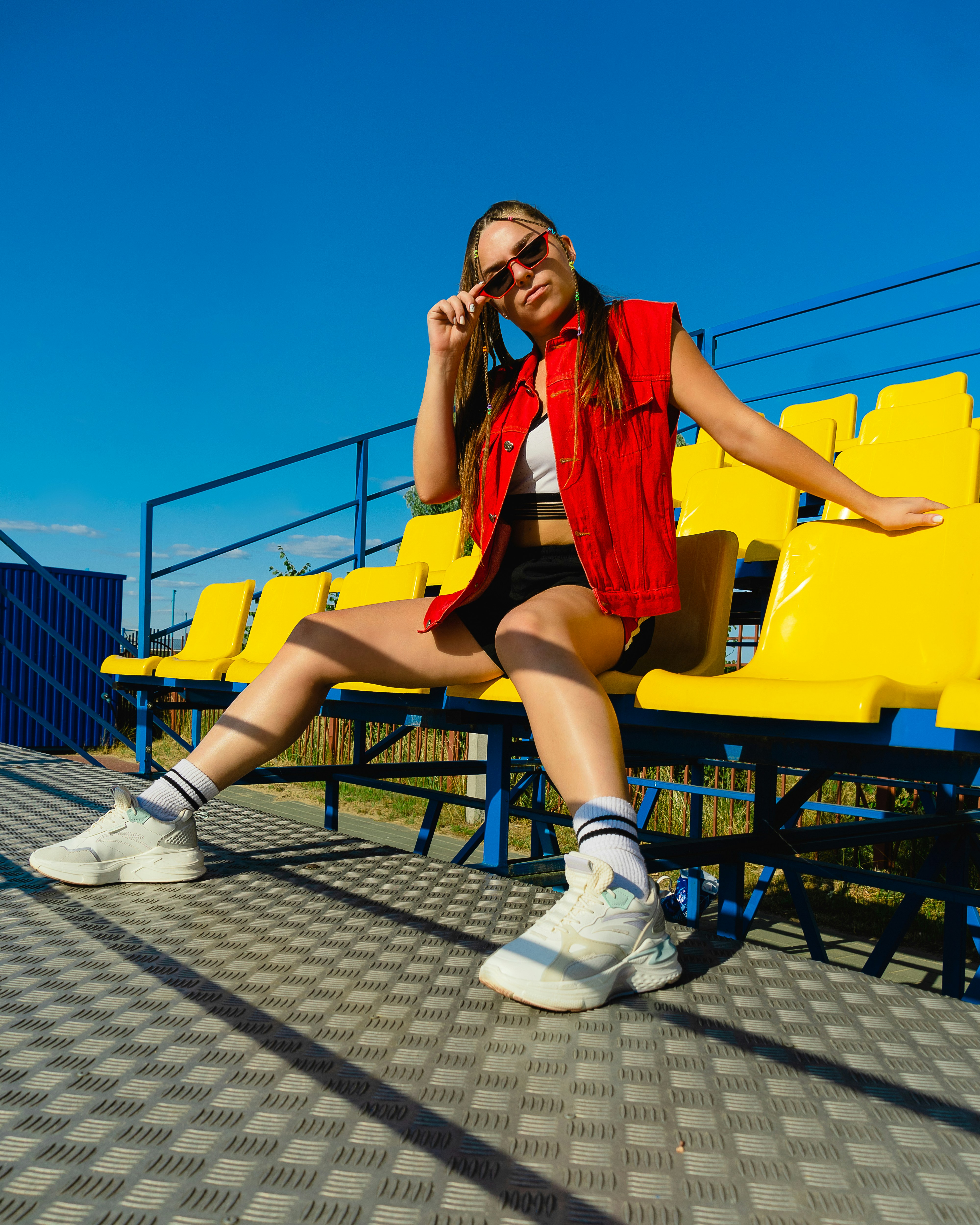 A woman sitting on a bench in front of a row of yellow chairs