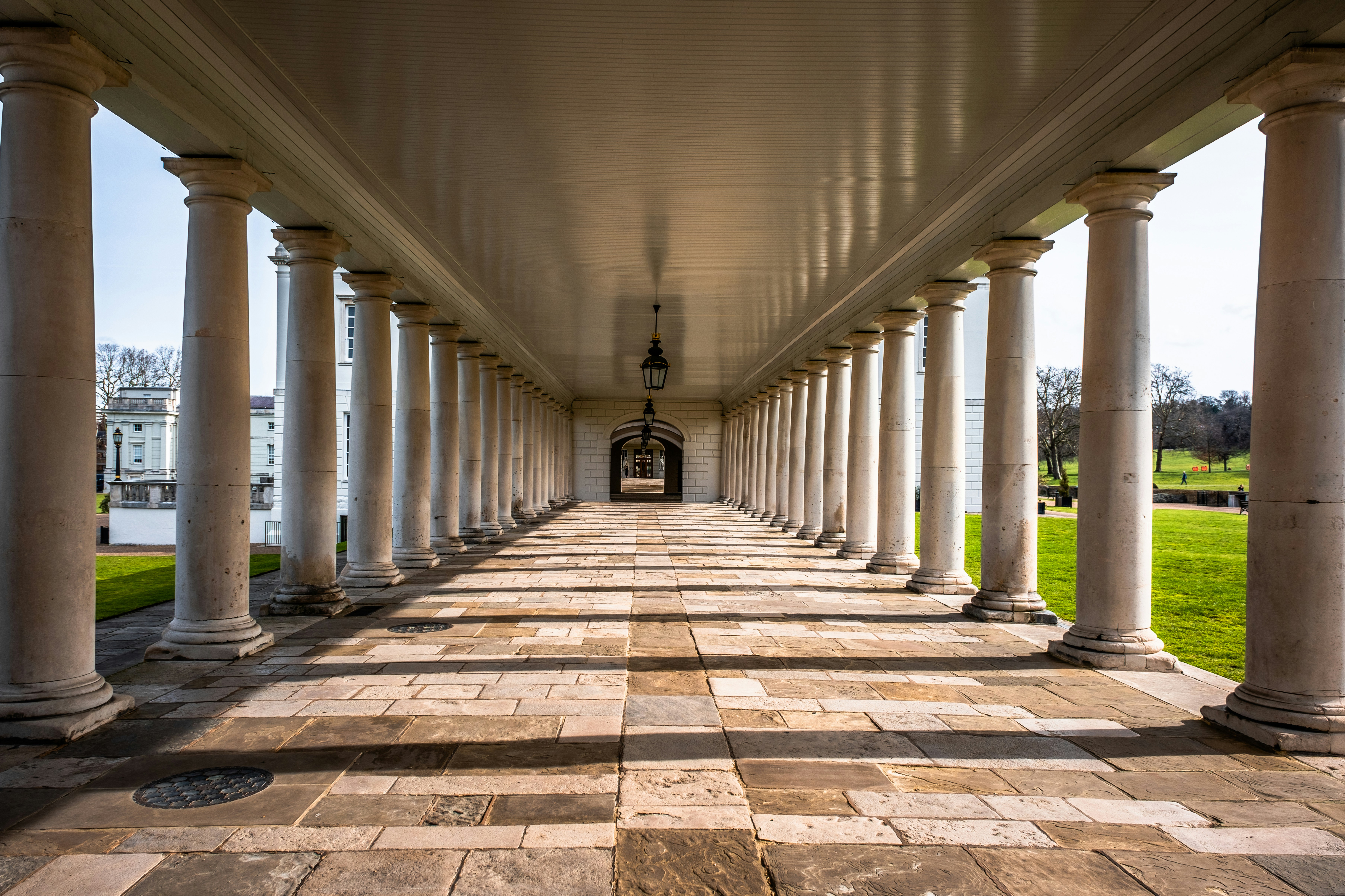 A long walkway with columns and a clock