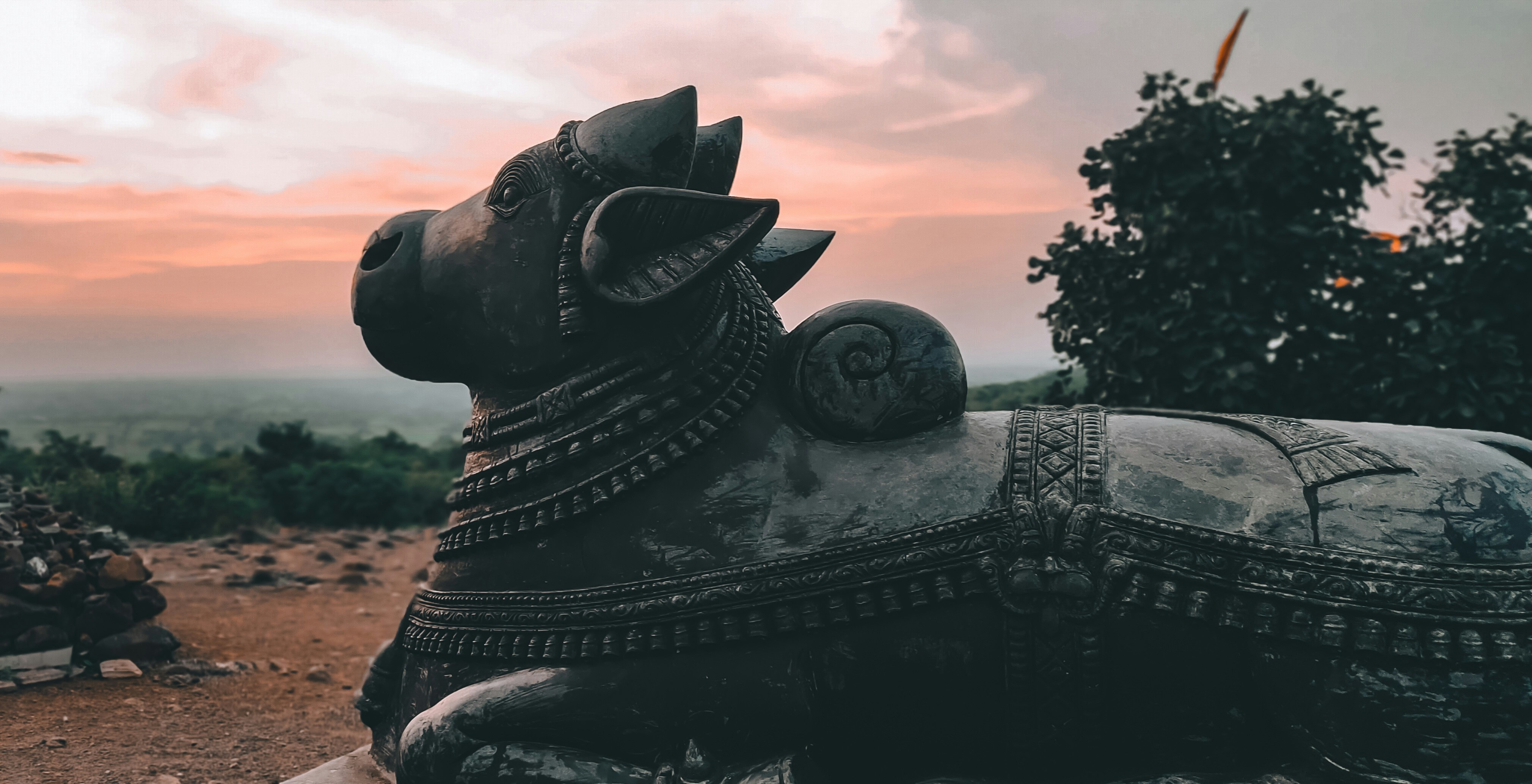 A statue sitting on top of a dirt field