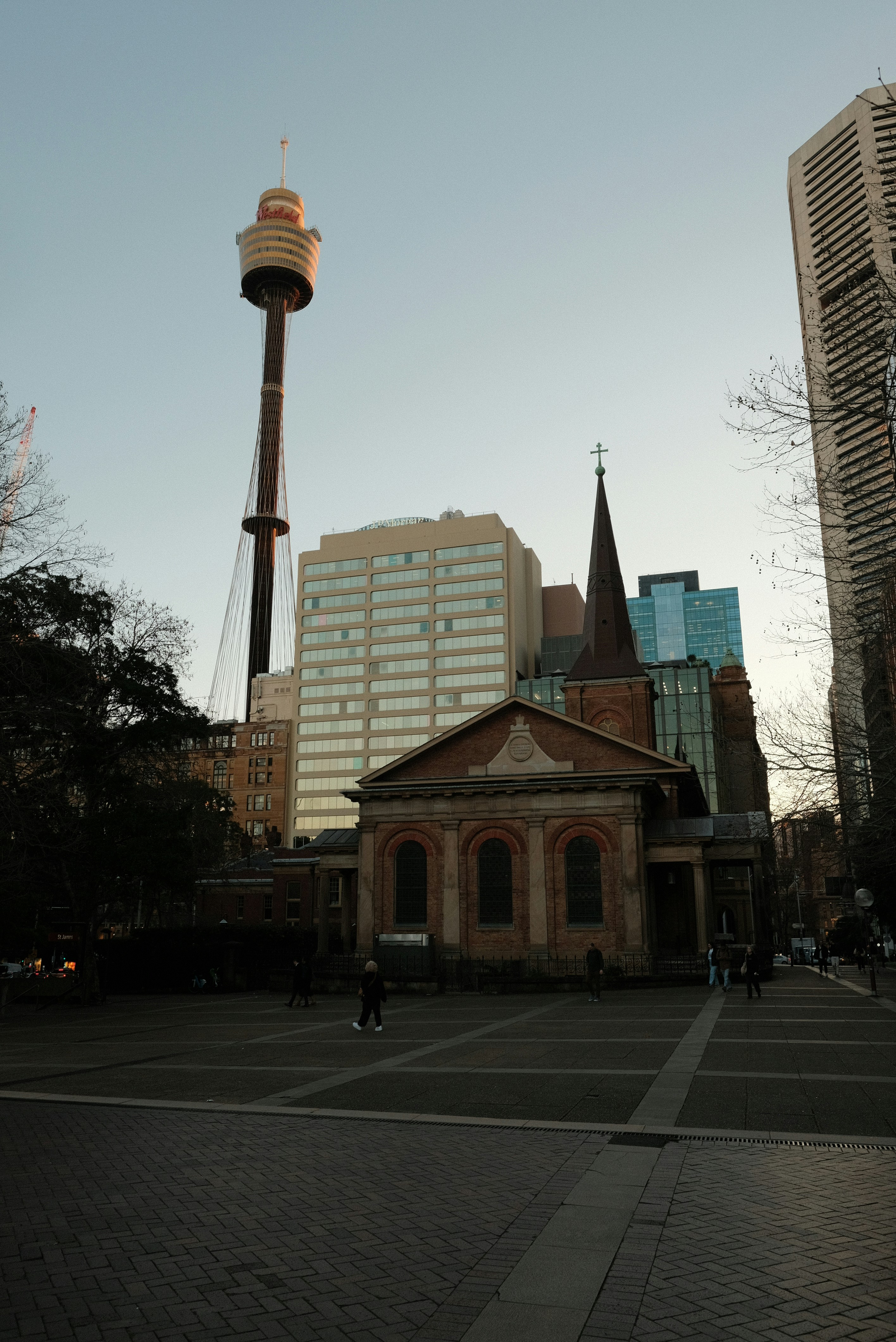 Una iglesia en medio de una ciudad con altos edificios al fondo