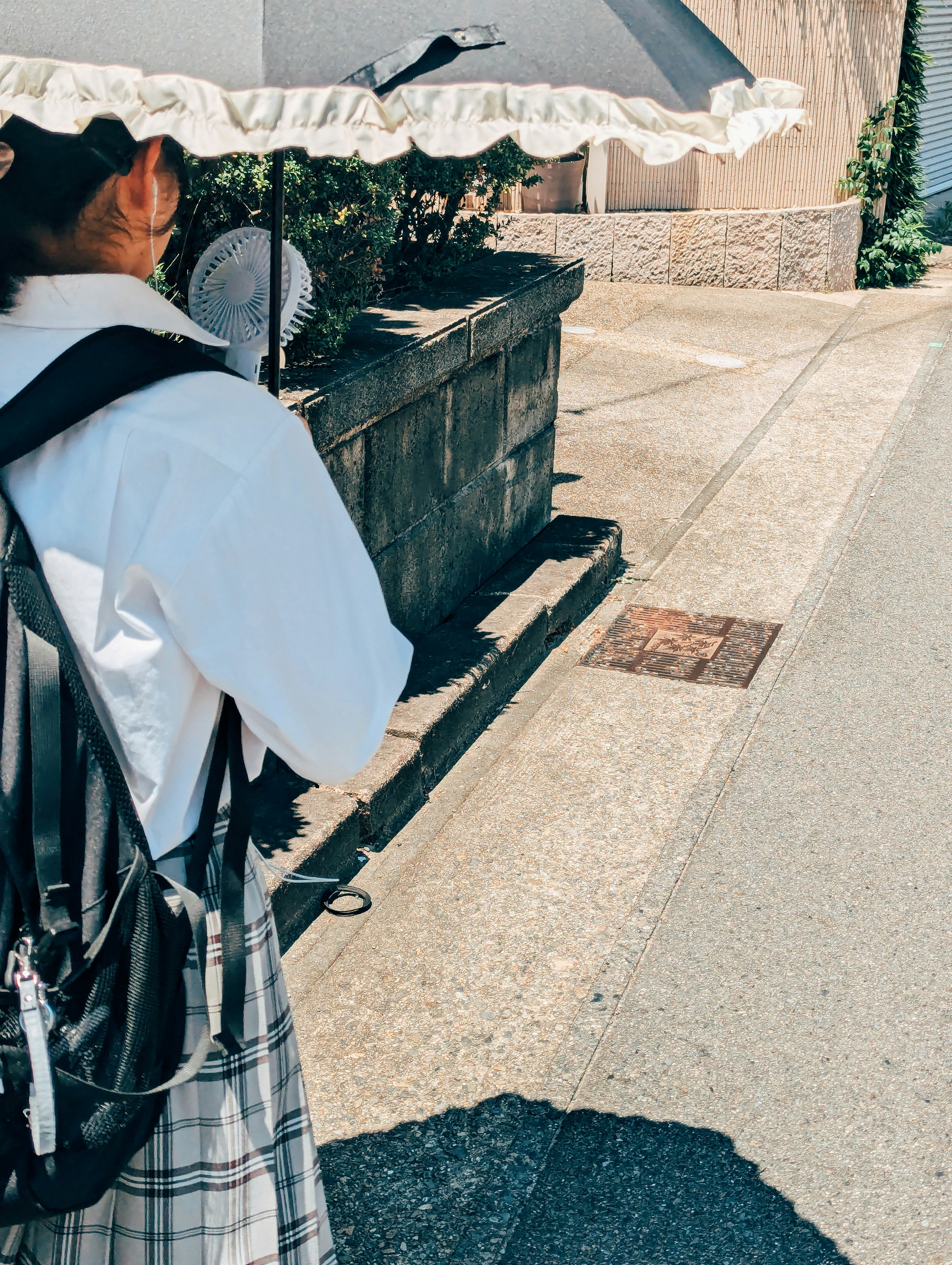 Una donna che tiene un ombrello sul lato di una strada
