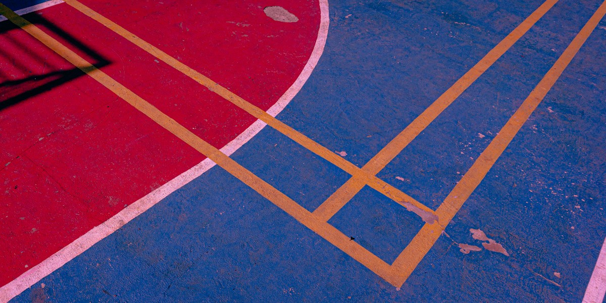 Close-up of a basketball court with painted lines, ideal for indoor gym games for kids in elementary PE classes.