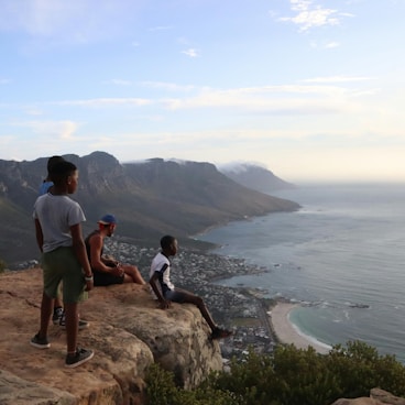 A group of people sitting on top of a cliff