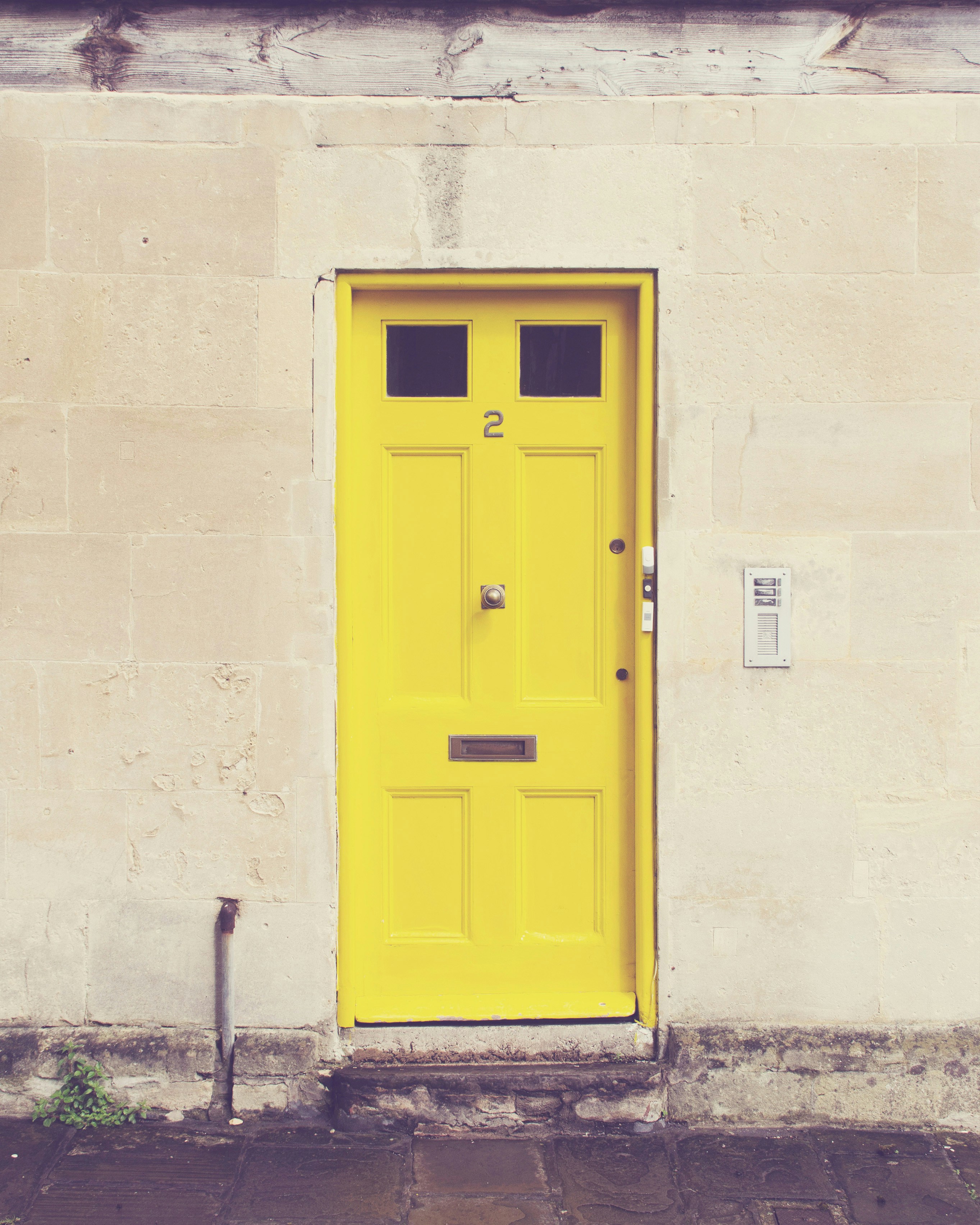 Uma porta amarela em um prédio branco