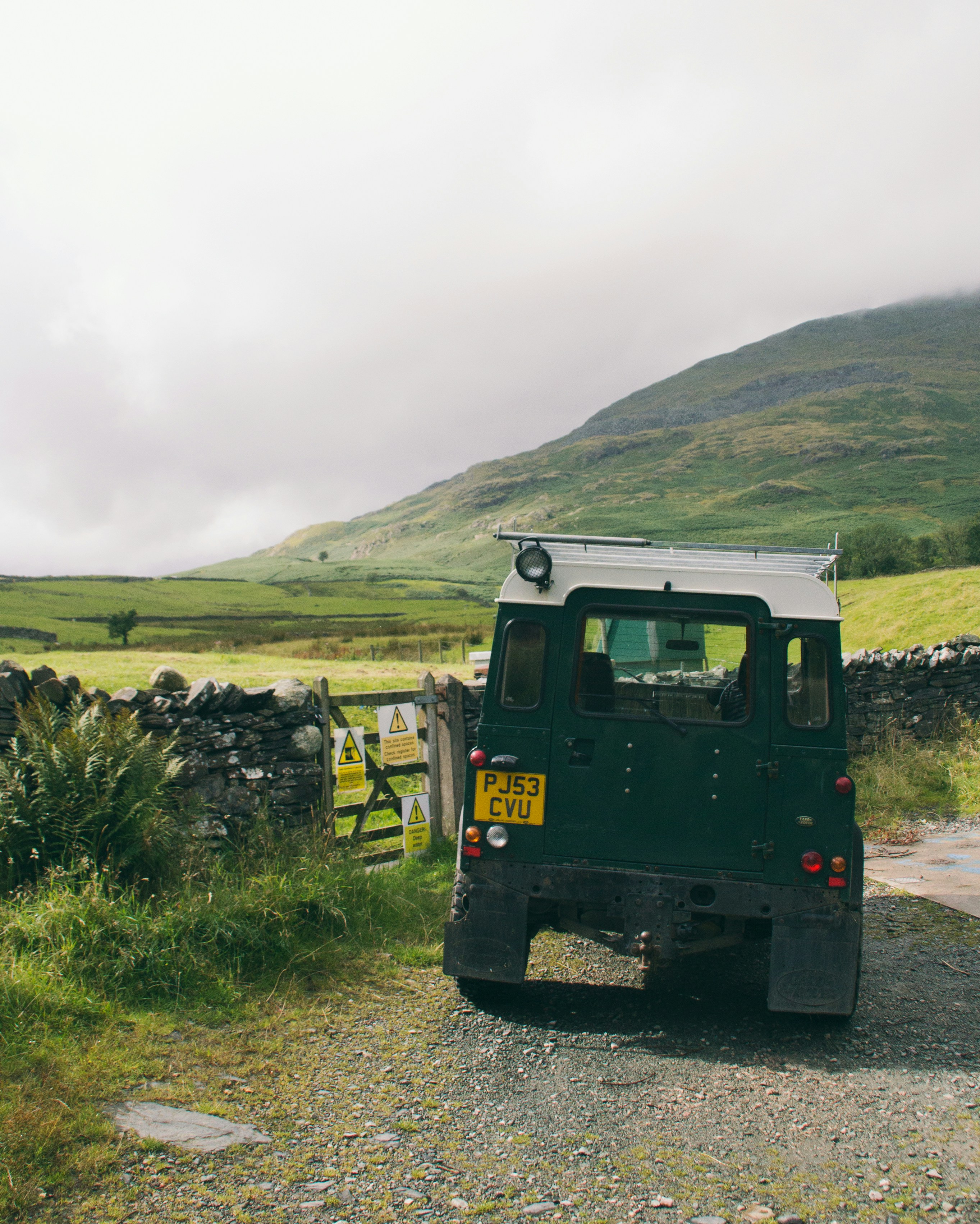 Um veículo estacionado ao lado de uma estrada de terra
