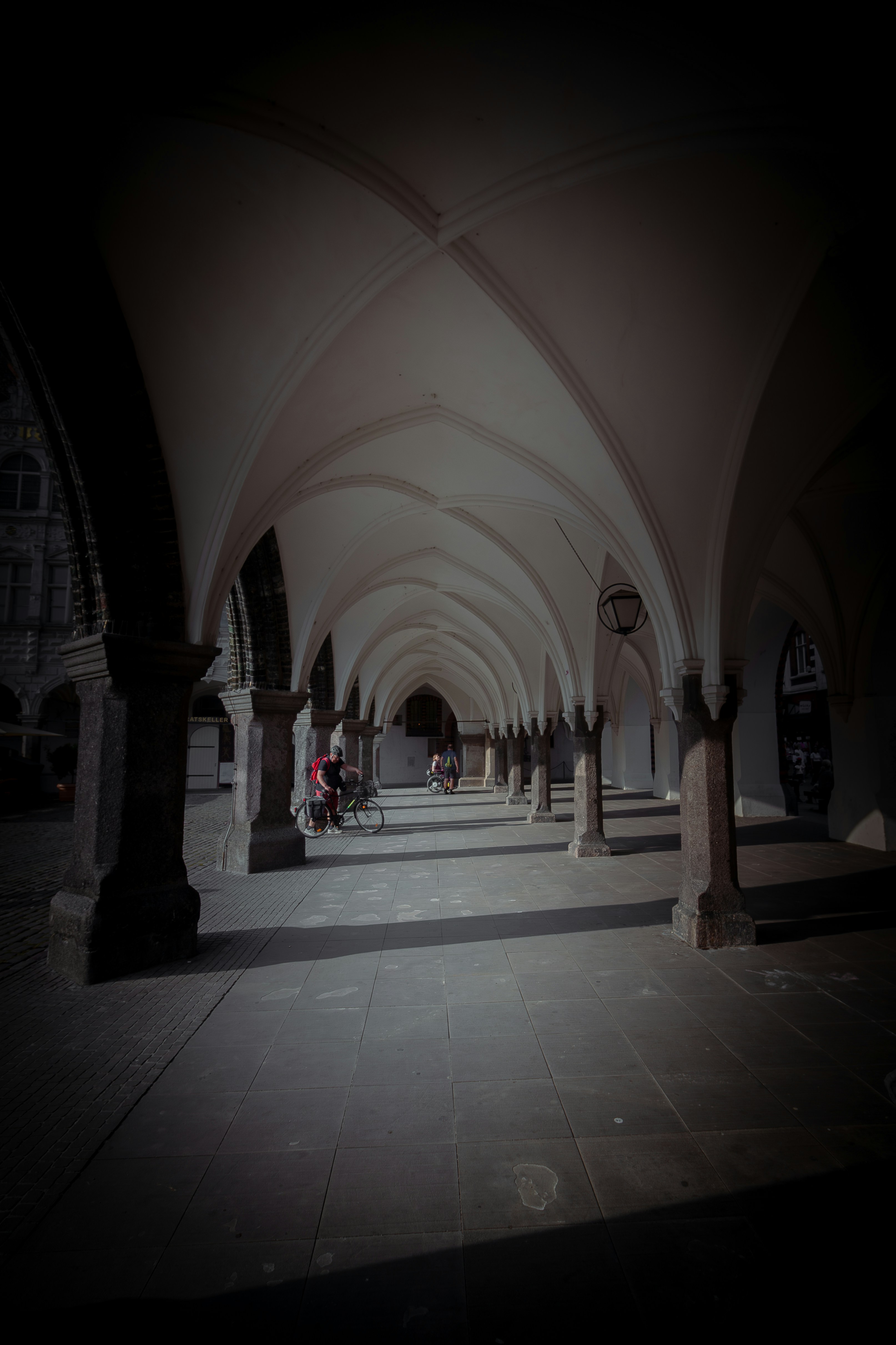 A dimly lit hallway with columns and arches