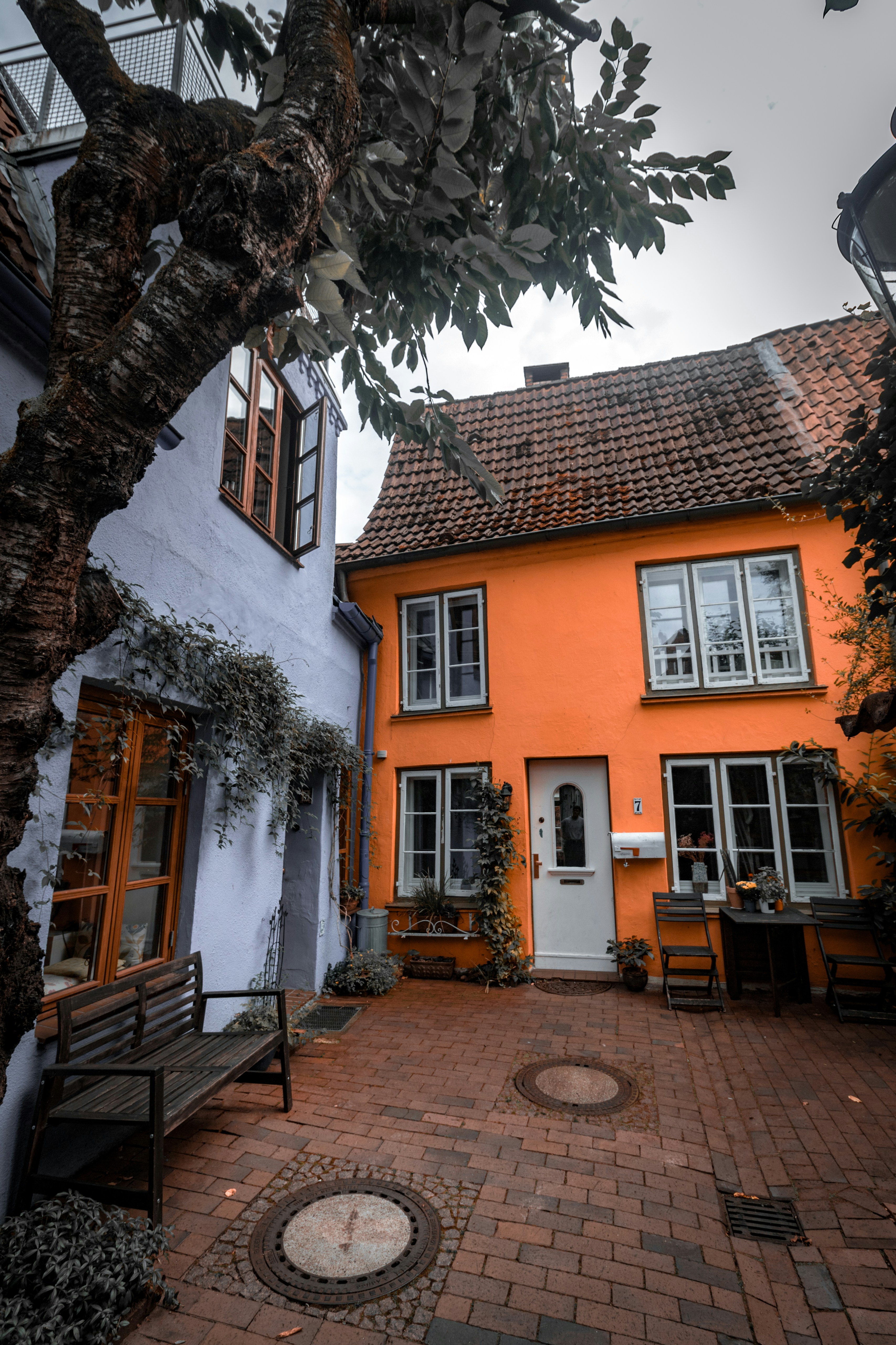 An orange house with a bench in front of it