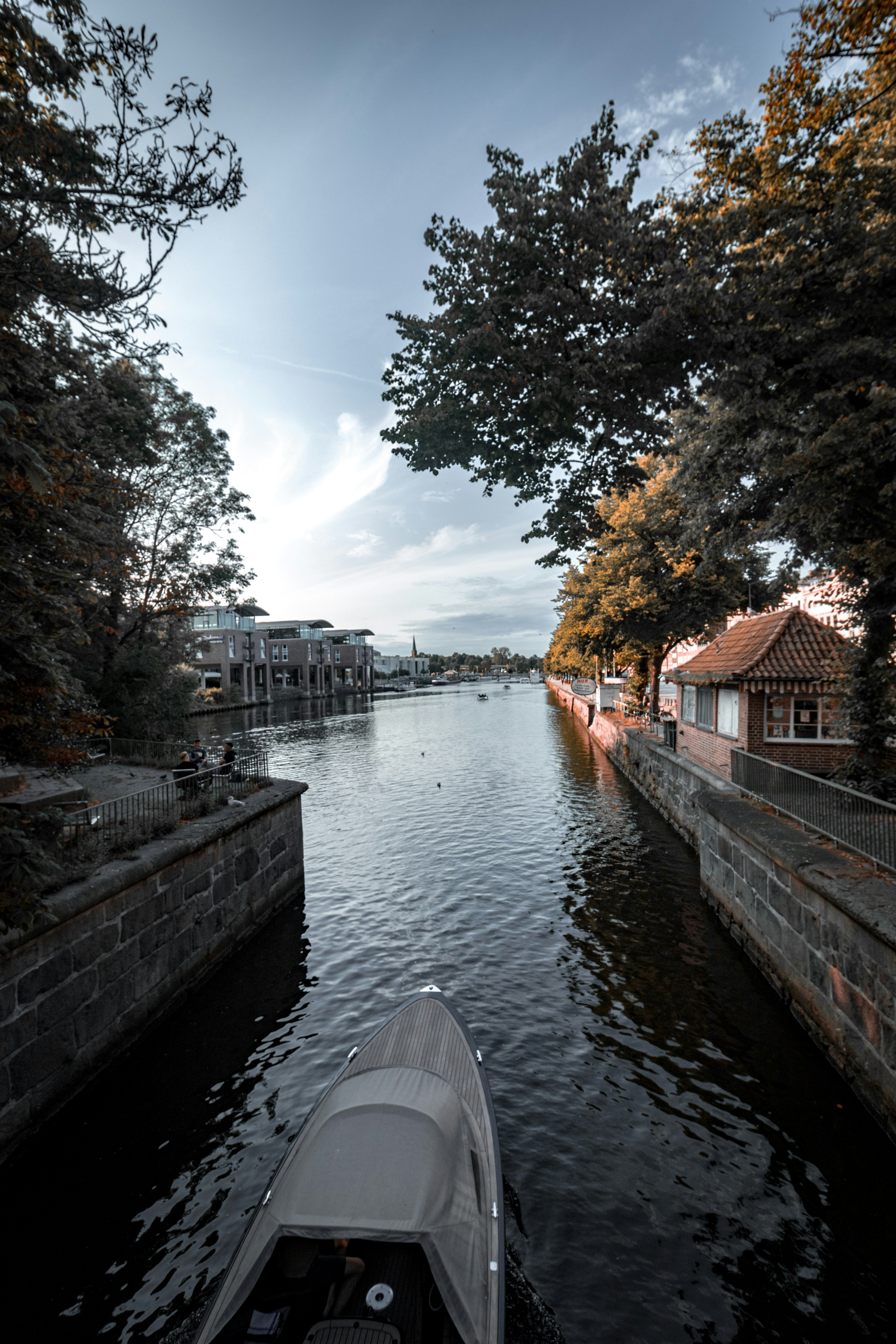 A boat traveling down a river surrounded by trees