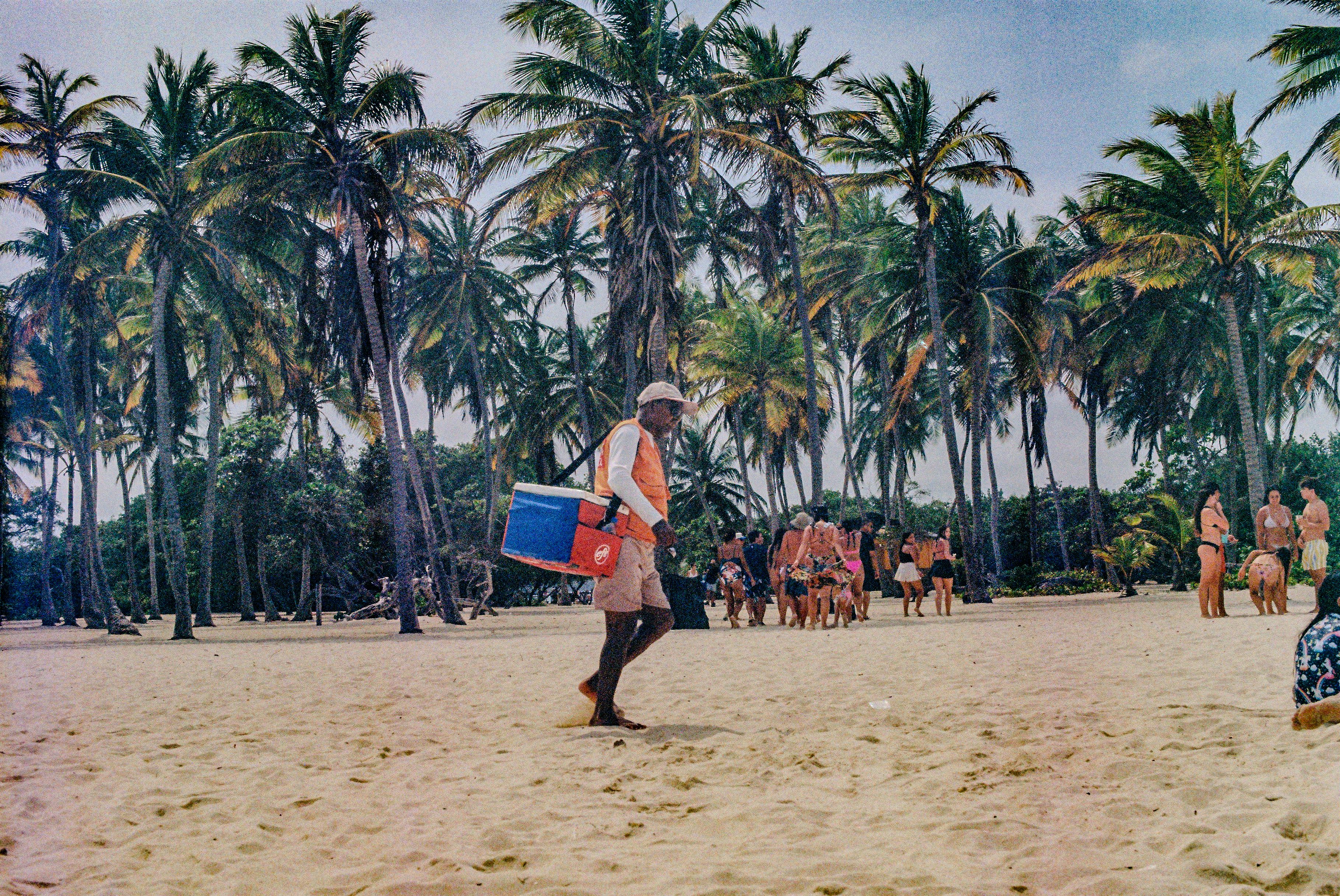 A group of people walking across a sandy beach