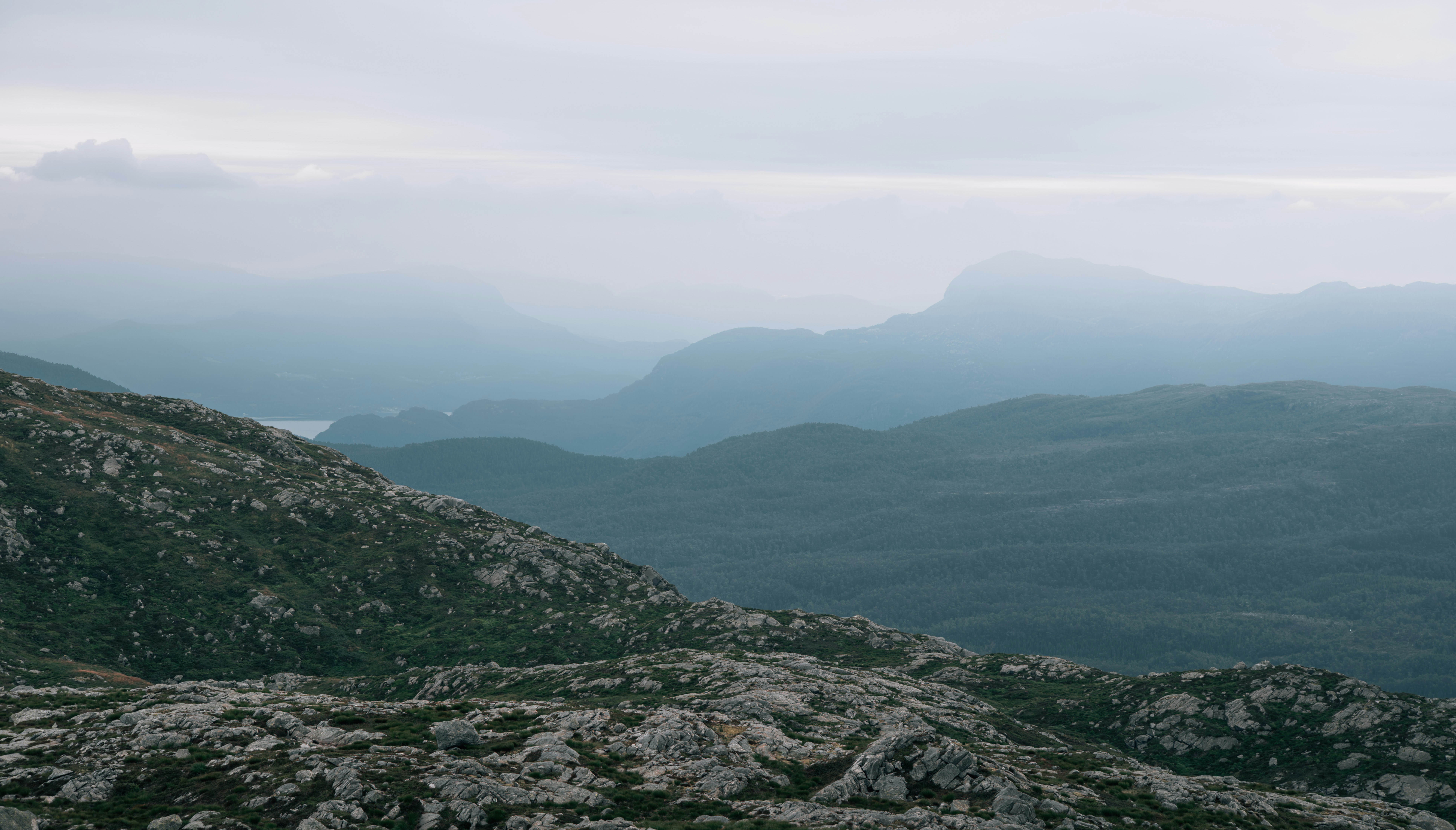 A person standing on top of a mountain with a backpack