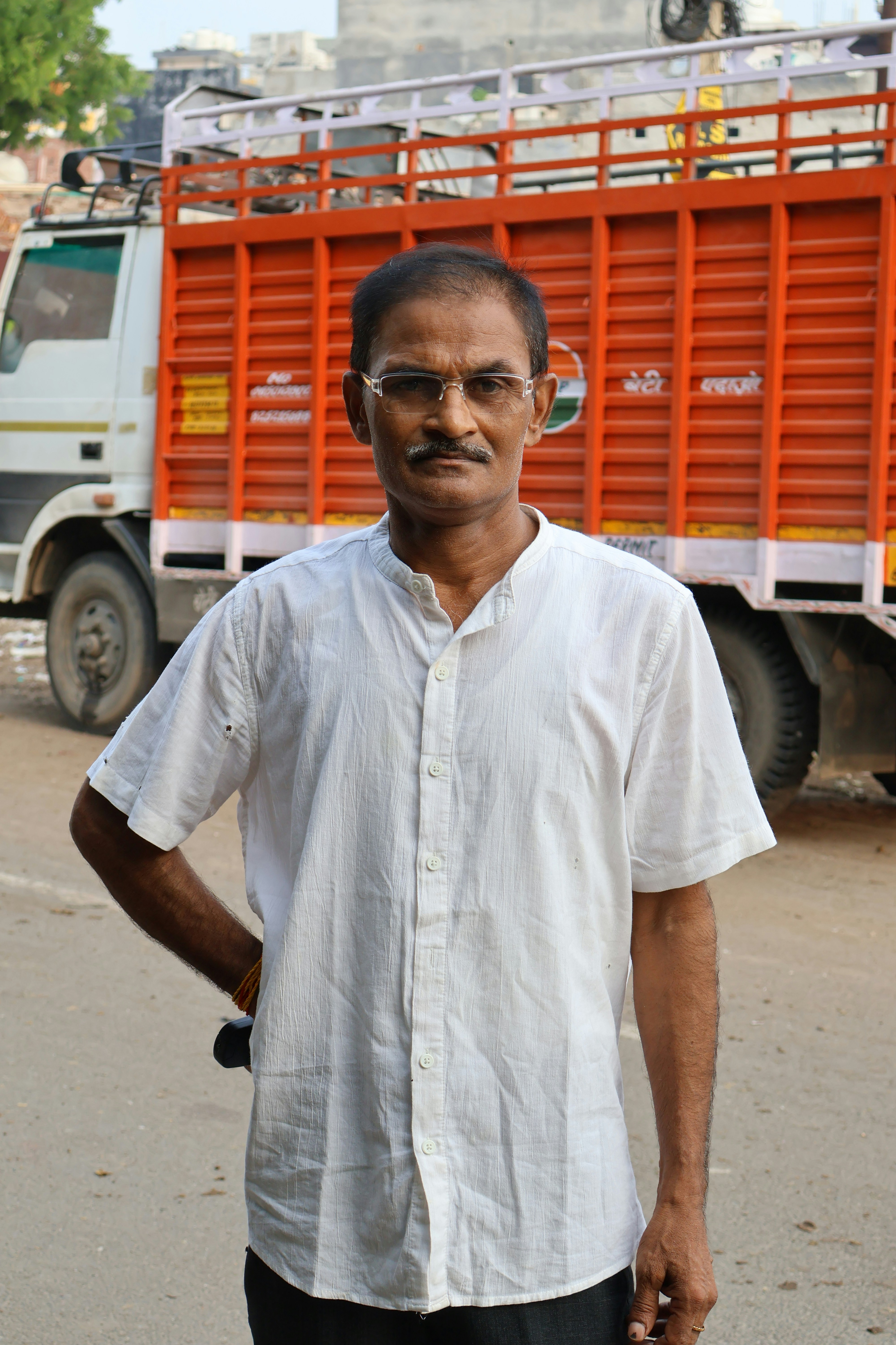 A man standing in front of a truck on a street
