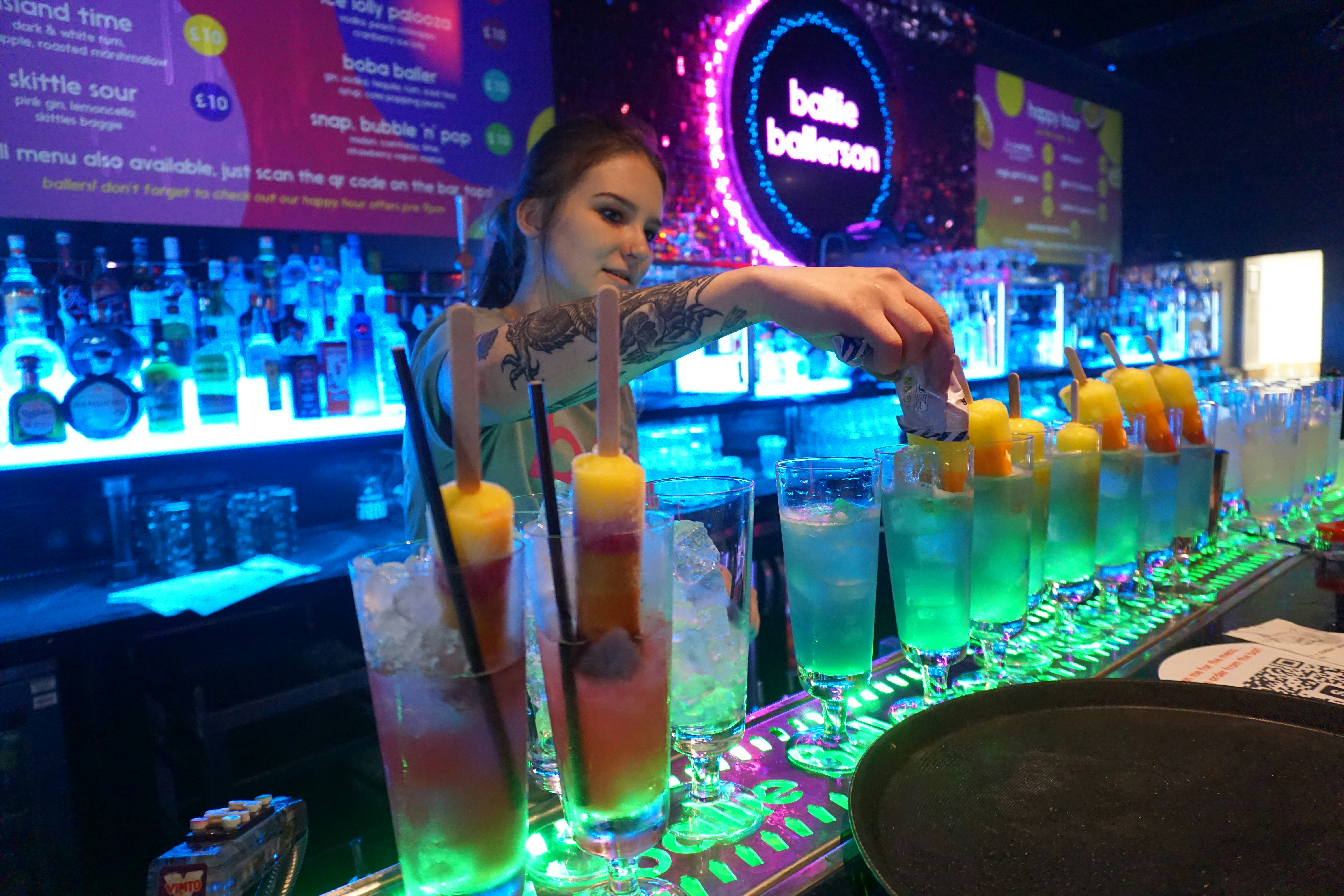 A woman is making a drink at a bar