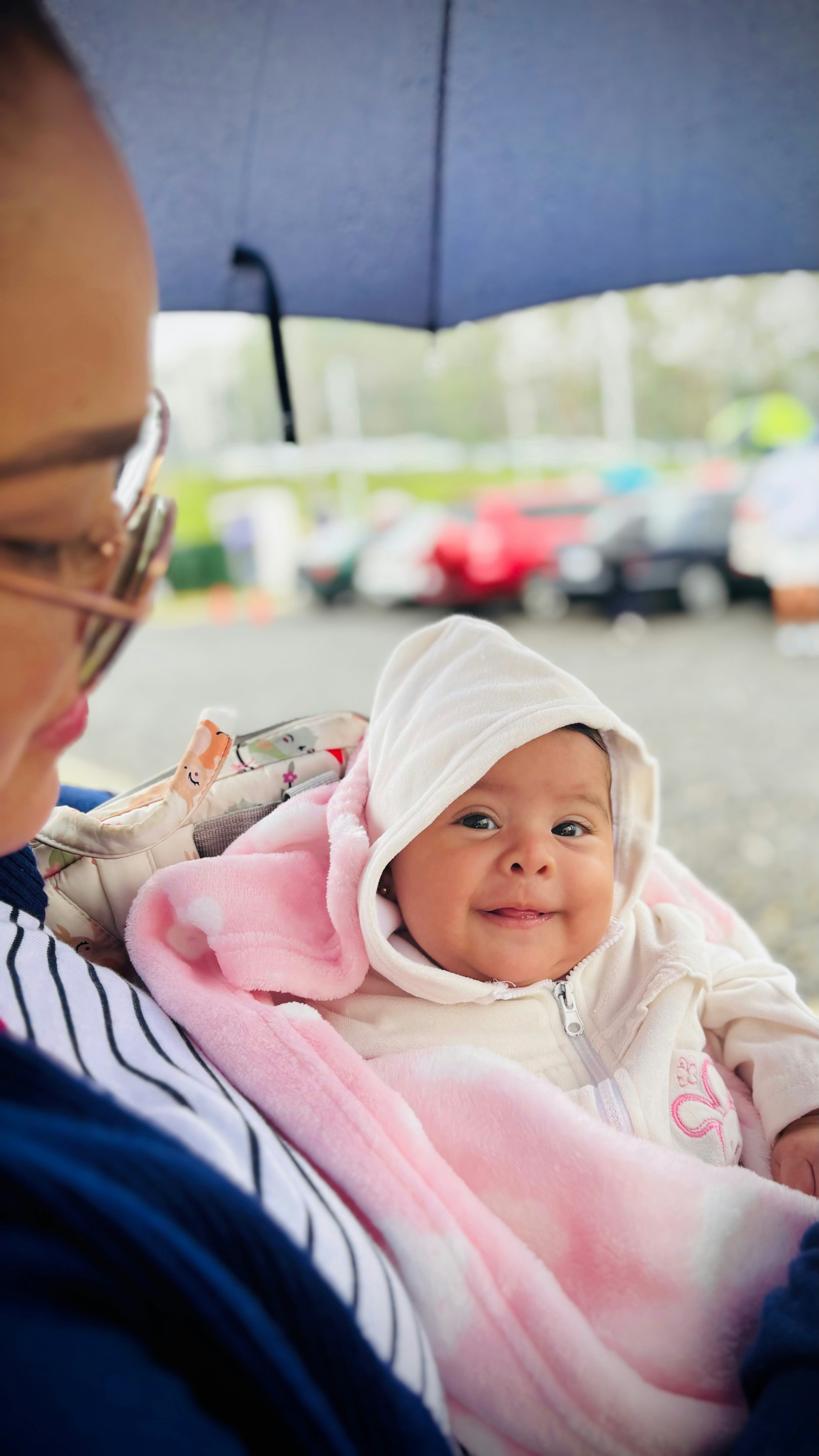 Eine Frau, die ein Baby unter einem Regenschirm hält