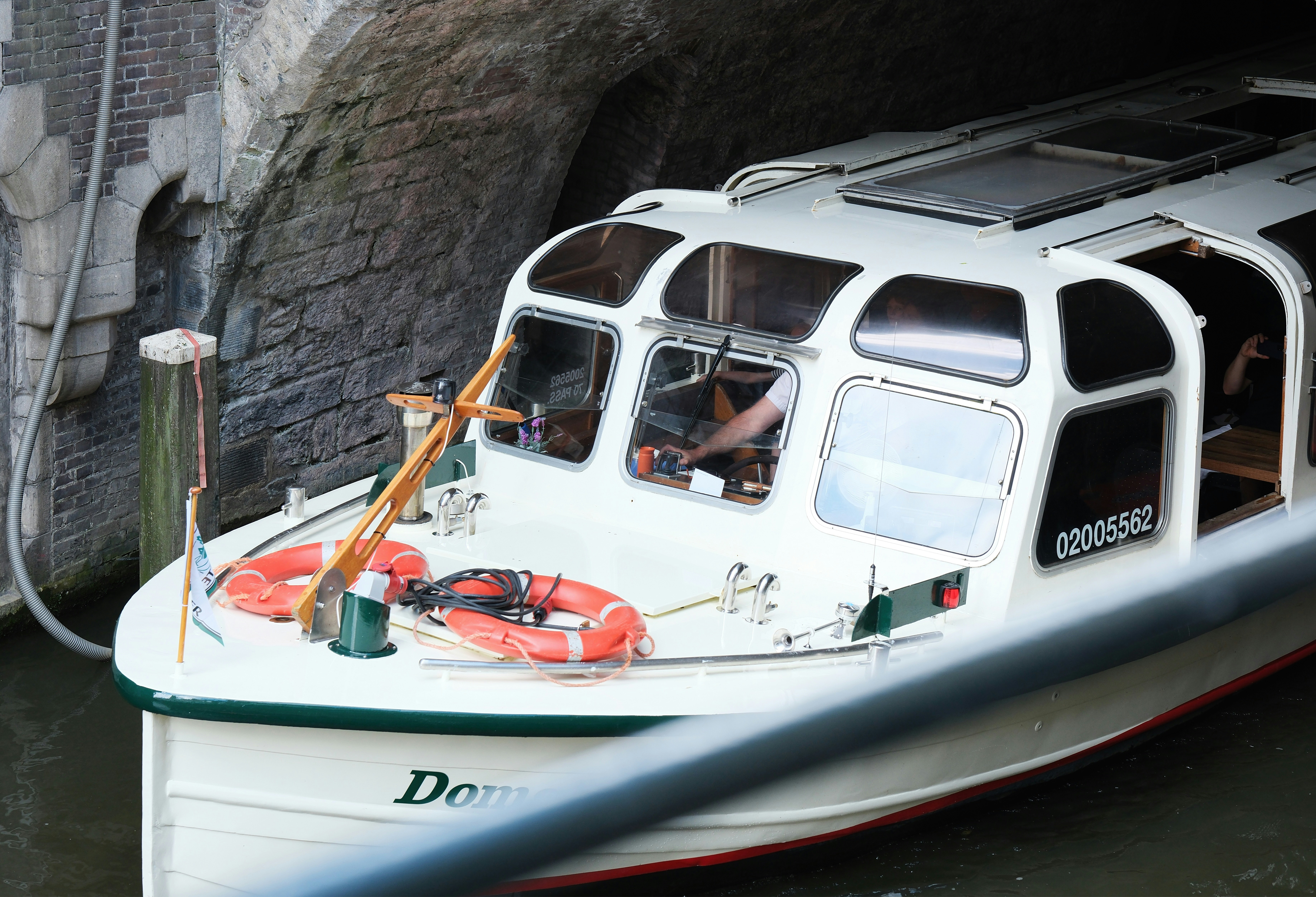 A small white boat in a body of water, Utrecht, Netherlands, a river cruise boat