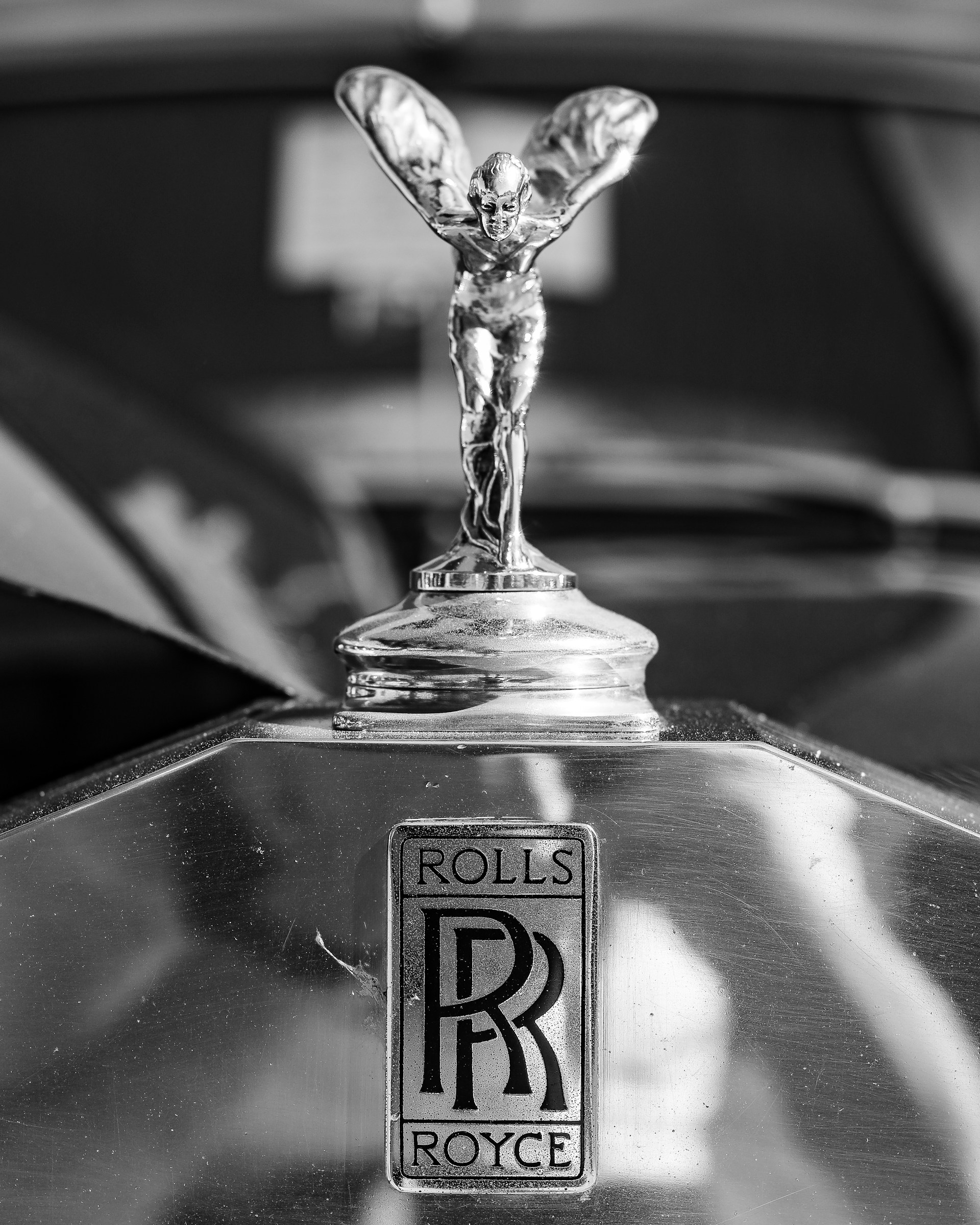 A black and white photo of a rolls royce emblem