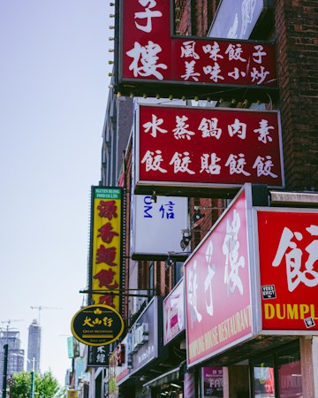 Stacked business signs covering the side of a multi-tenant commercial building, the kind of dense signage found along Spring Mountain Road