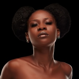 A woman with an afro is wearing a dress
