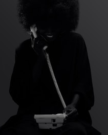 A woman sitting down talking on a phone