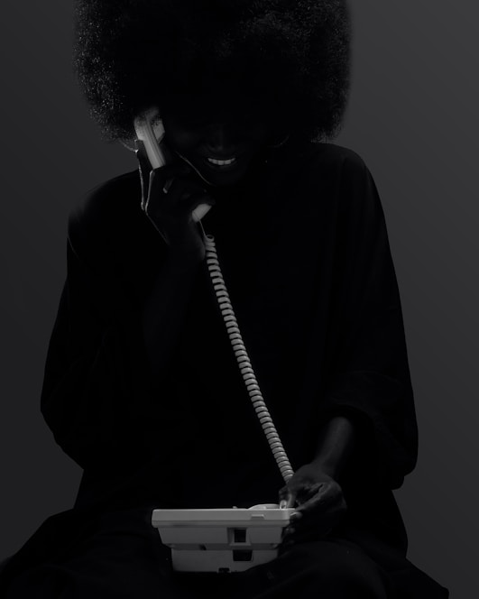 A woman sitting down talking on a phone