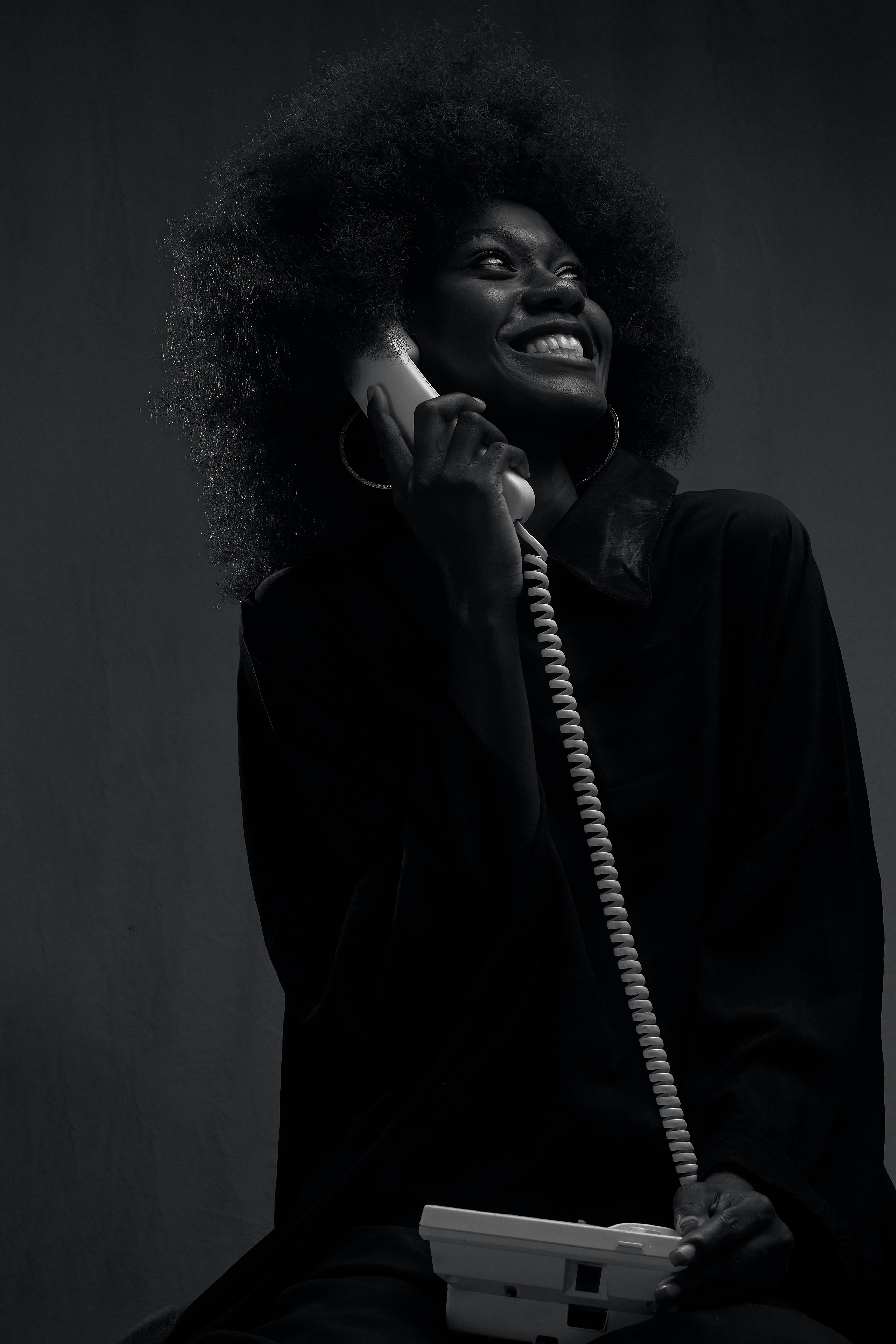 A black and white photo of a woman talking on a phone