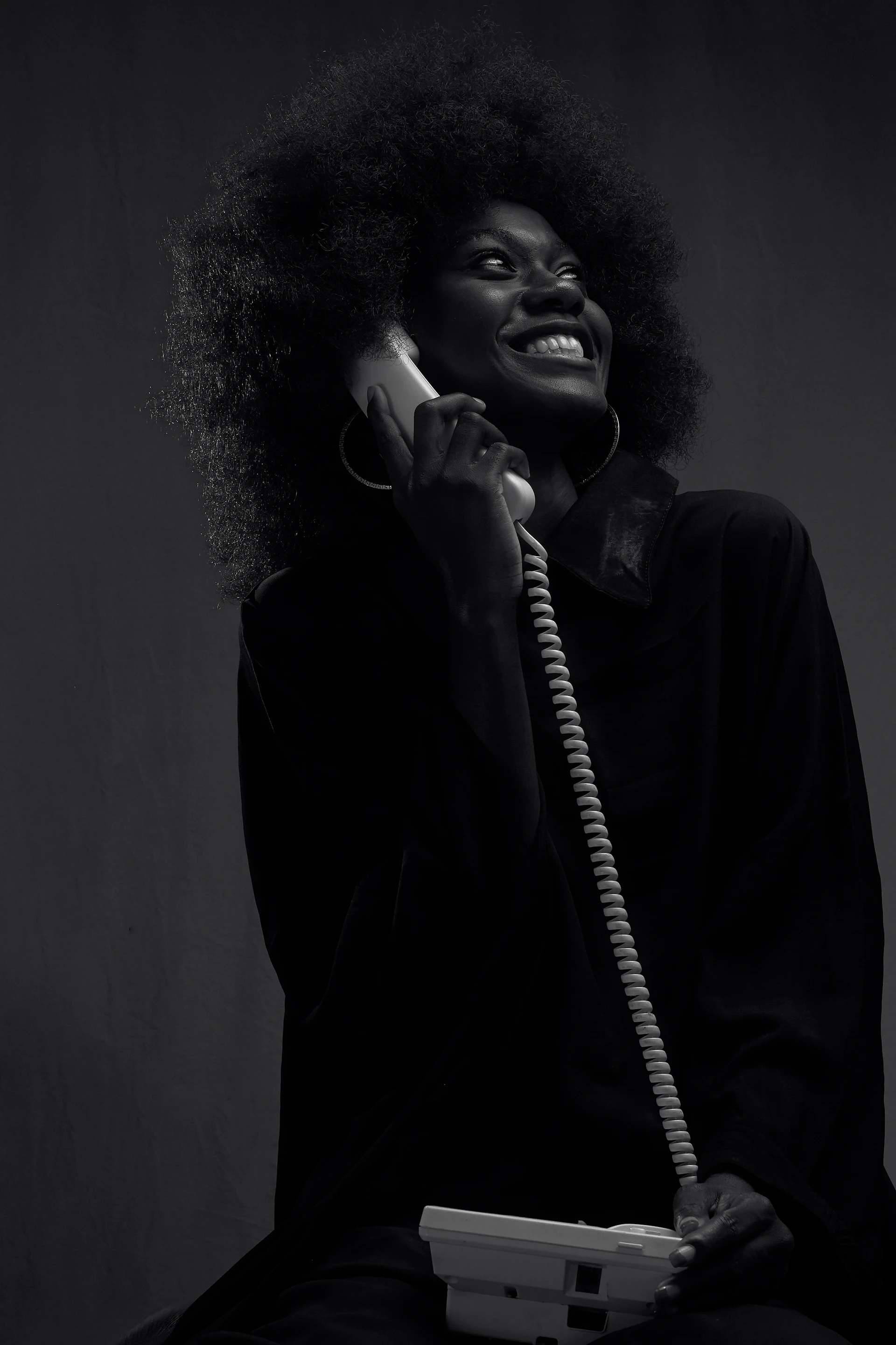A black and white photo of a woman talking on a phone