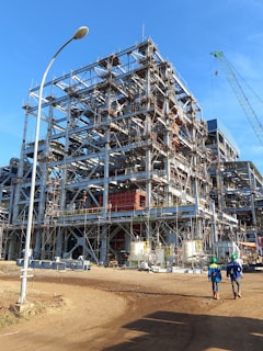 A large building under construction on a dirt road