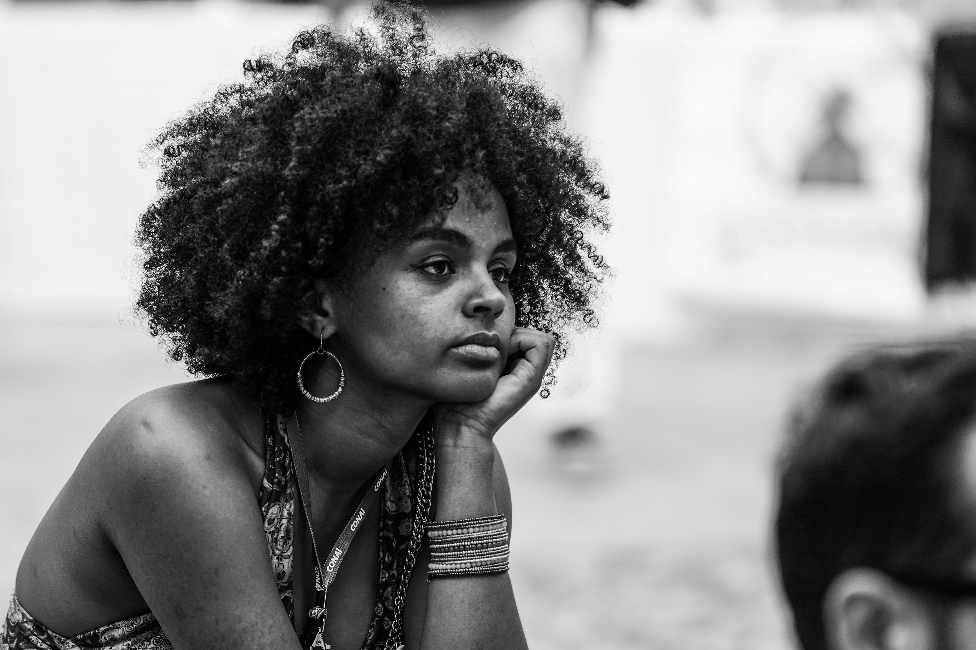 A black and white photo of a woman sitting on the ground