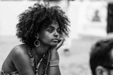 A black and white photo of a woman sitting on the ground