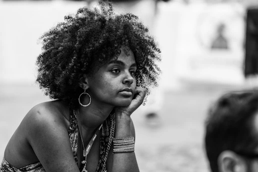 A black and white photo of a woman sitting on the ground
