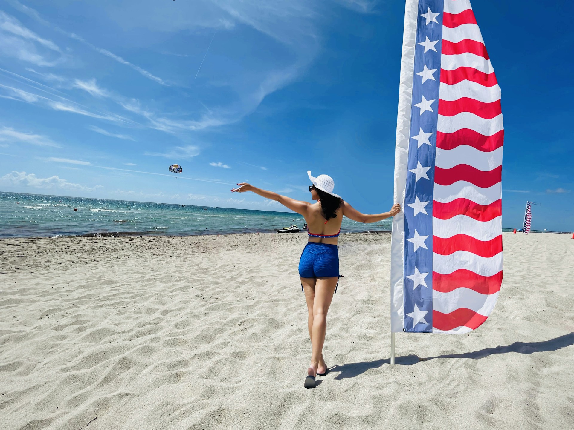A woman is holding a flag on the beach