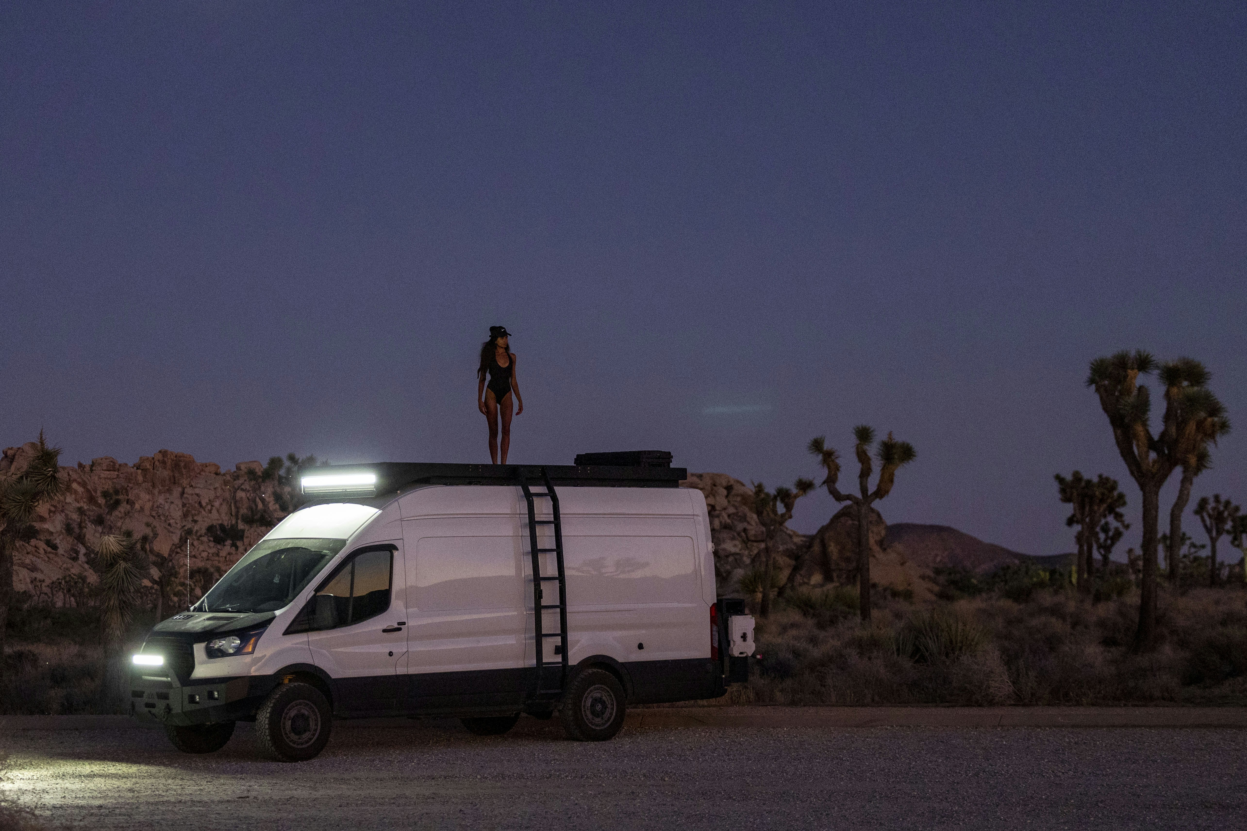 A person working on a laptop with a view of mountains and a lake, symbolizing digital nomad packing light for remote work, freedom, and travel.