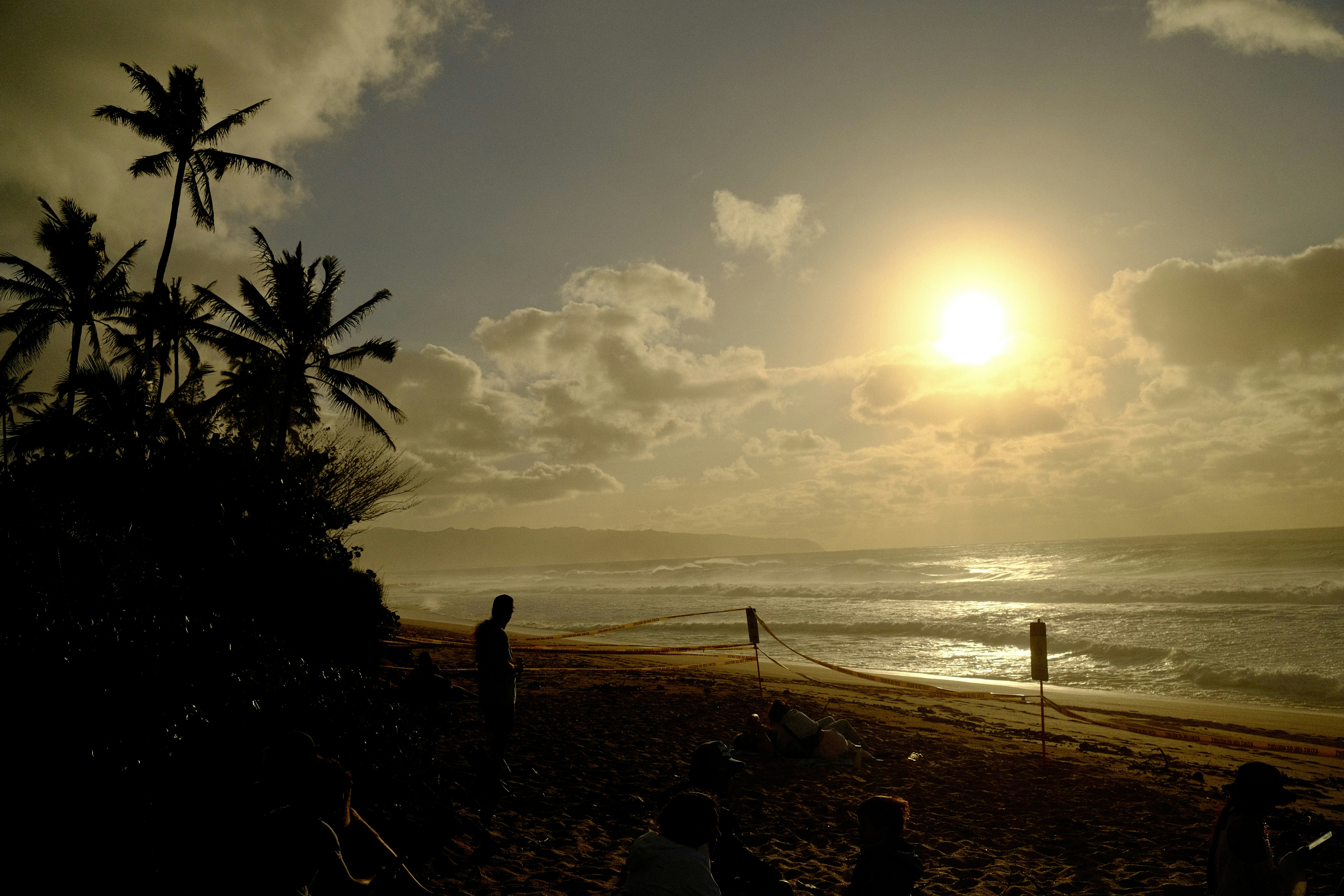 A group of people standing on top of a sandy beach