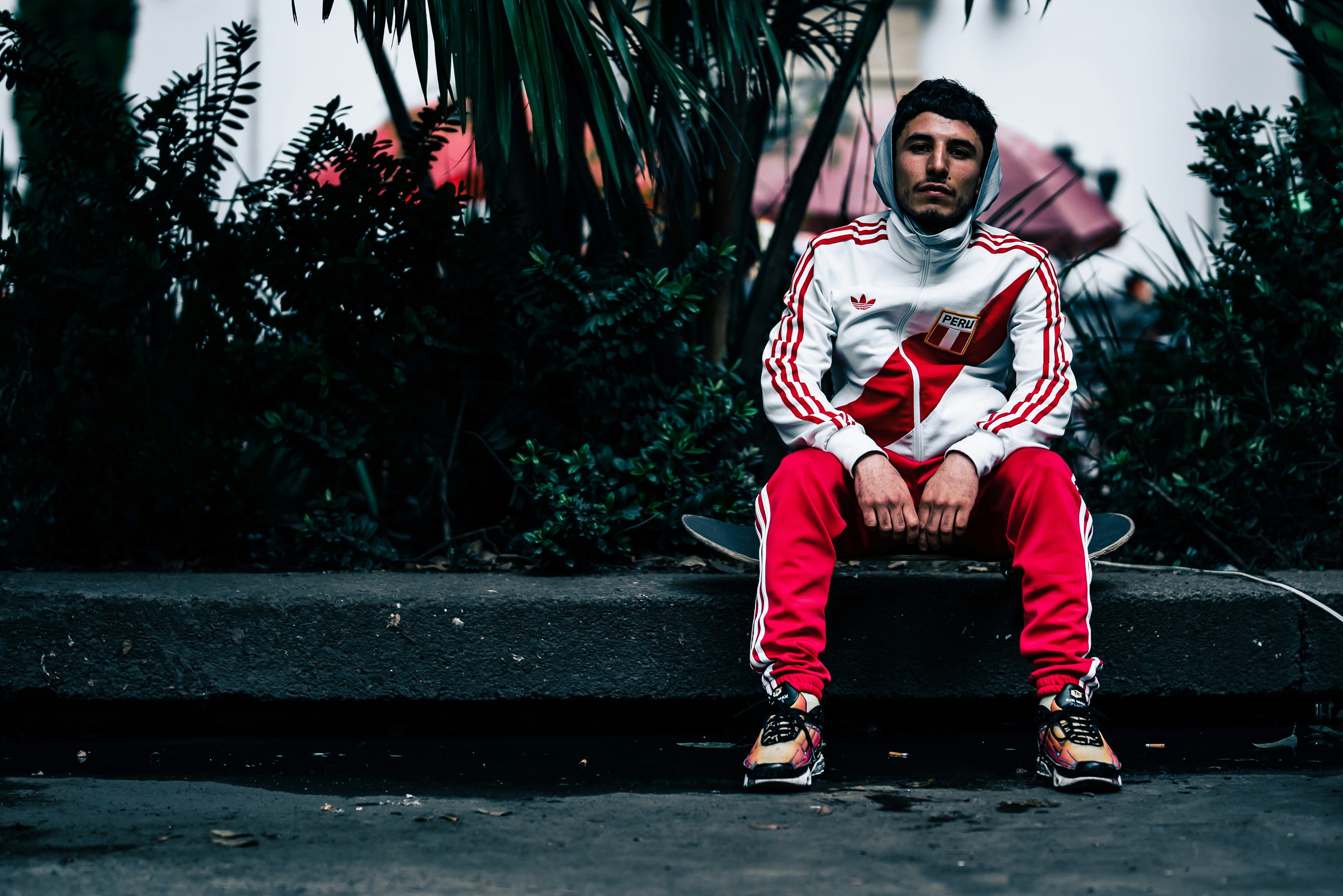 A man sitting on a bench in front of a palm tree