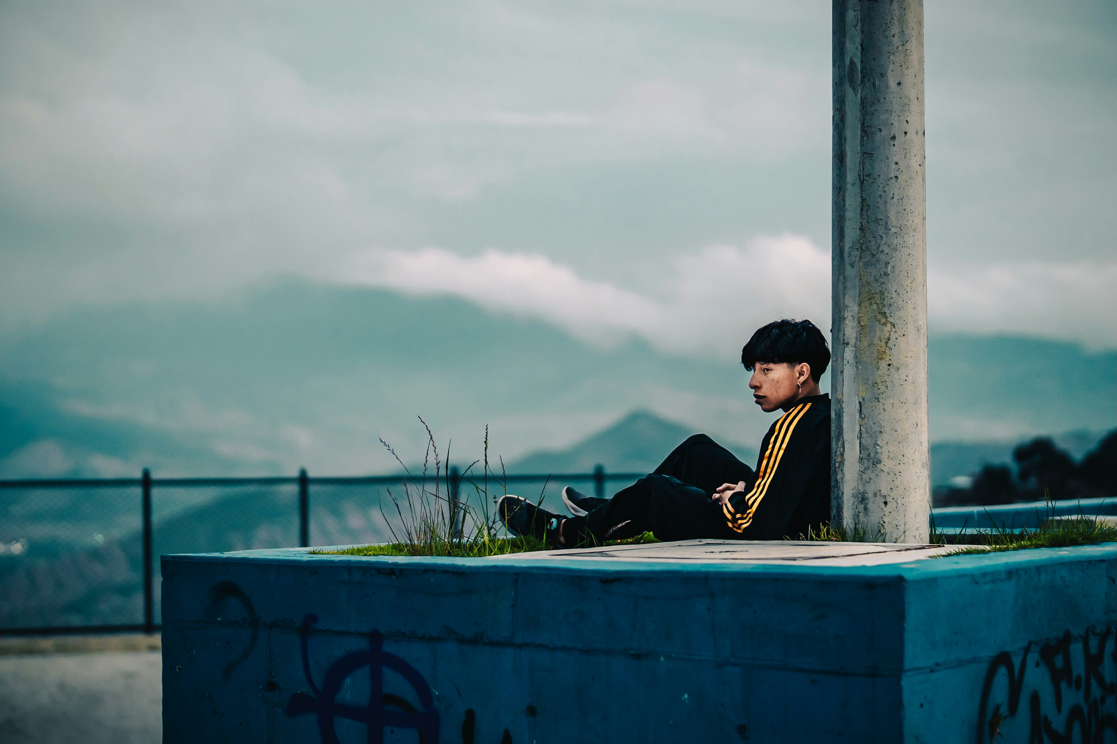 Un hombre sentado encima de una estructura de cemento