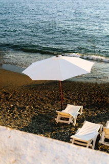 A couple of lawn chairs sitting on top of a beach