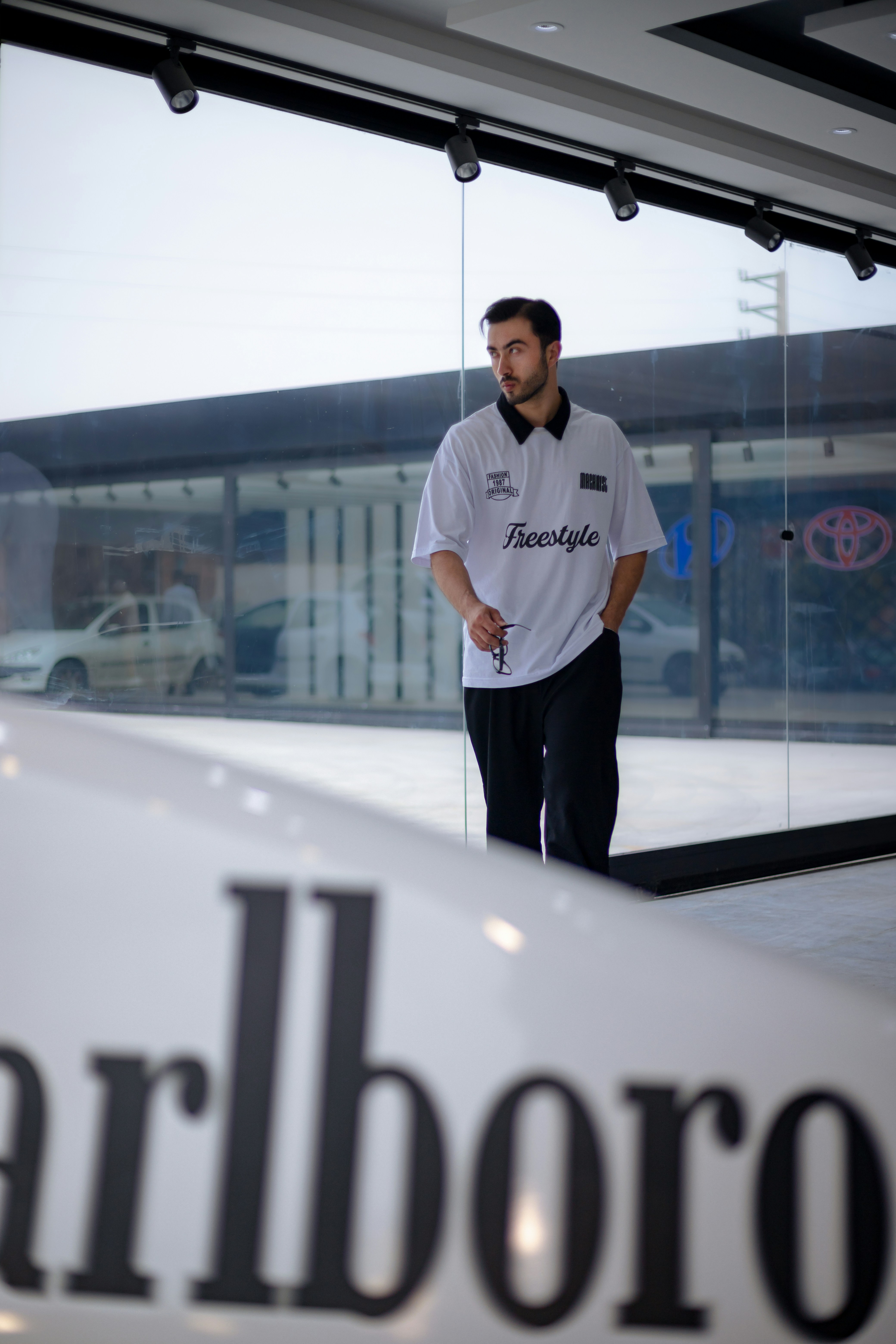 Un homme debout devant une pancarte Marlboro