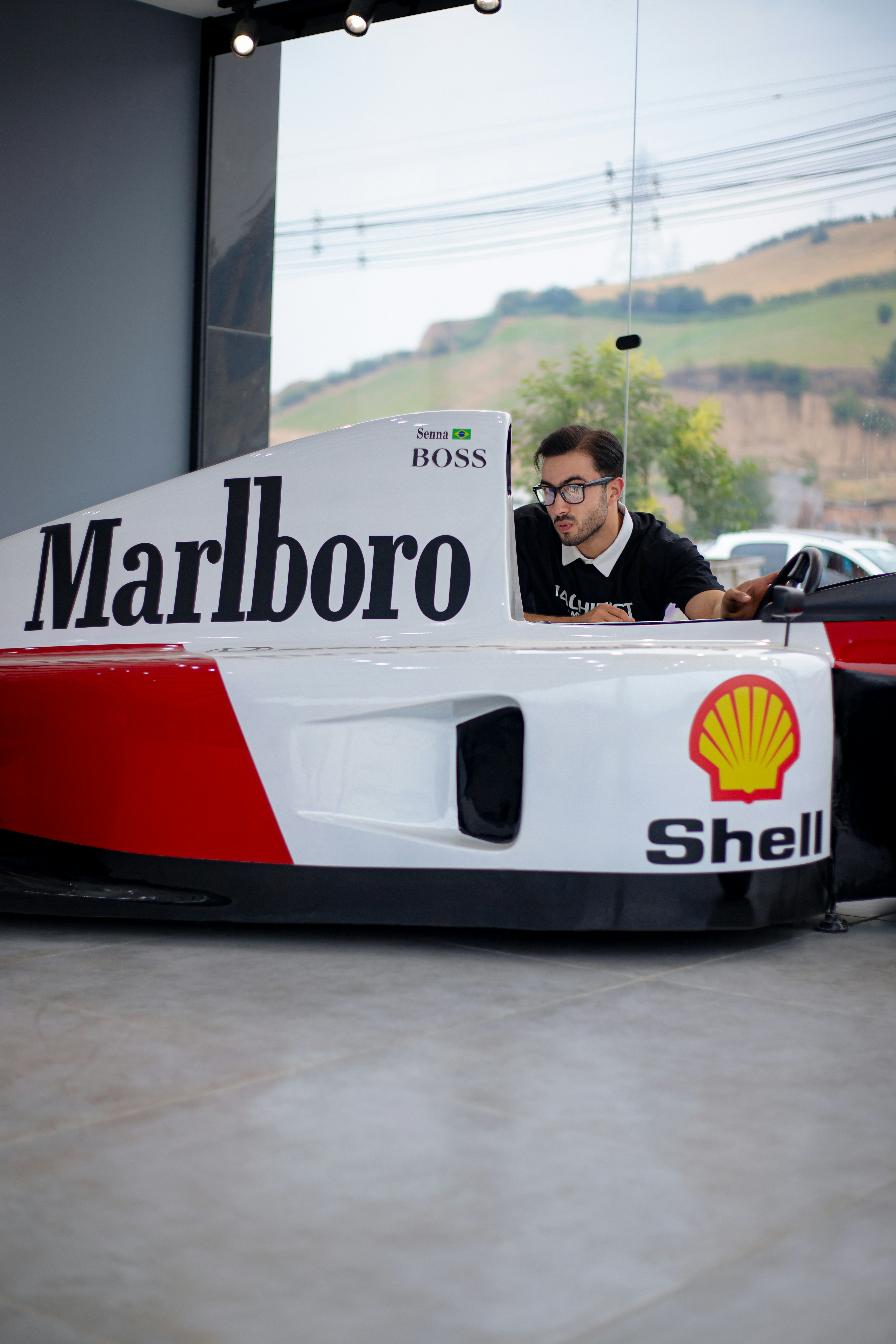A man sitting in a racing car in a garage