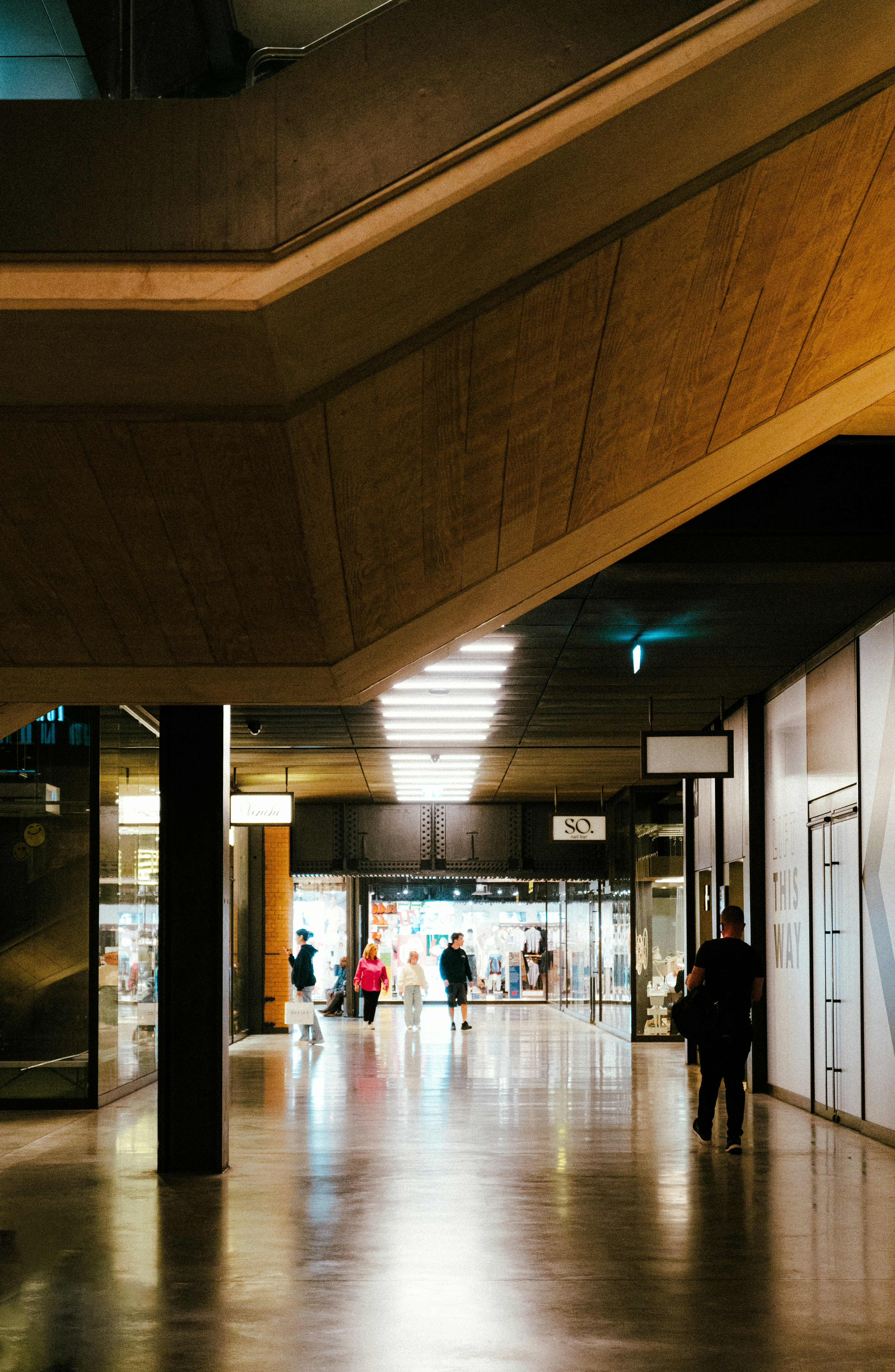 A group of people walking down a hallway in a building