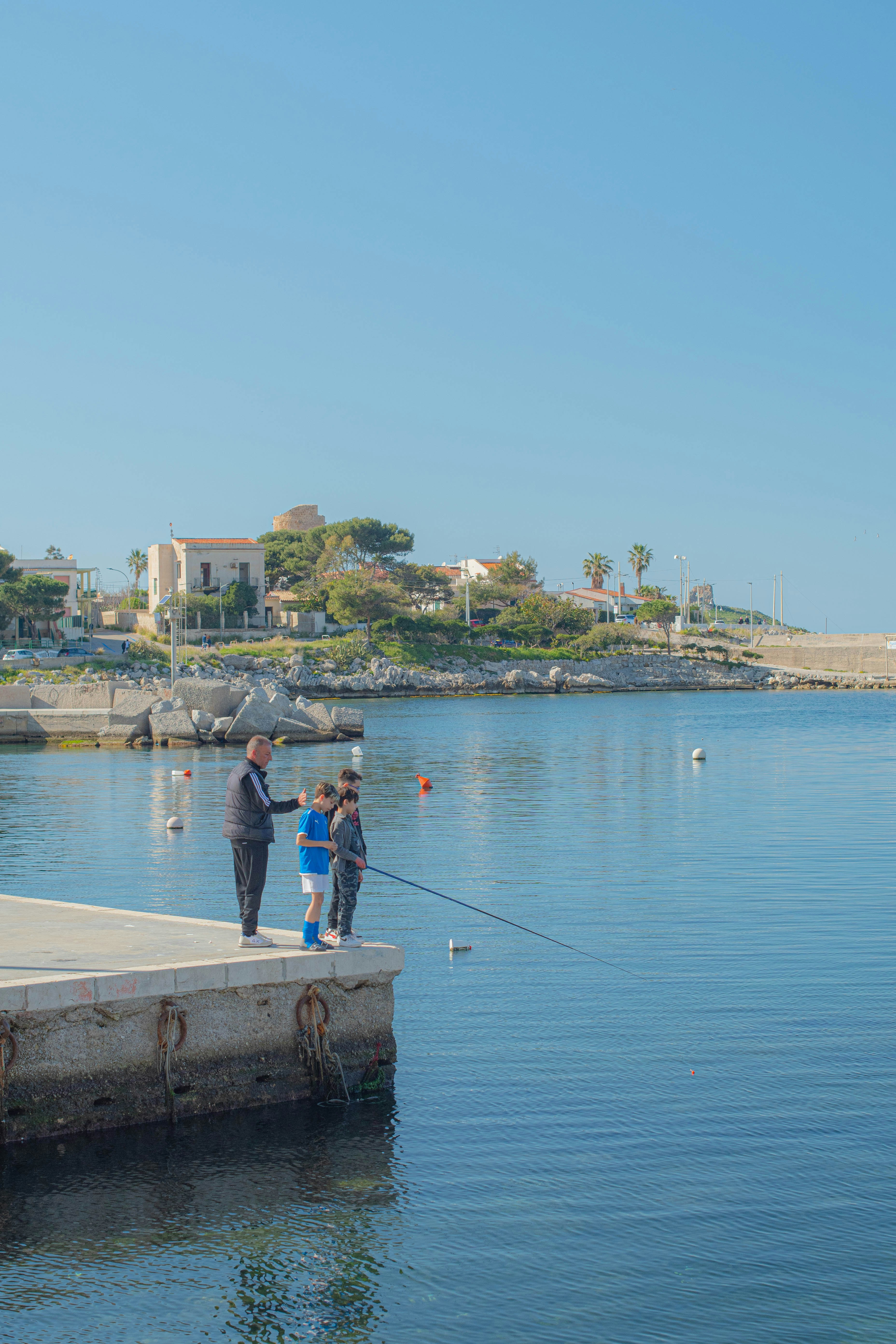 A couple of people standing on top of a pier