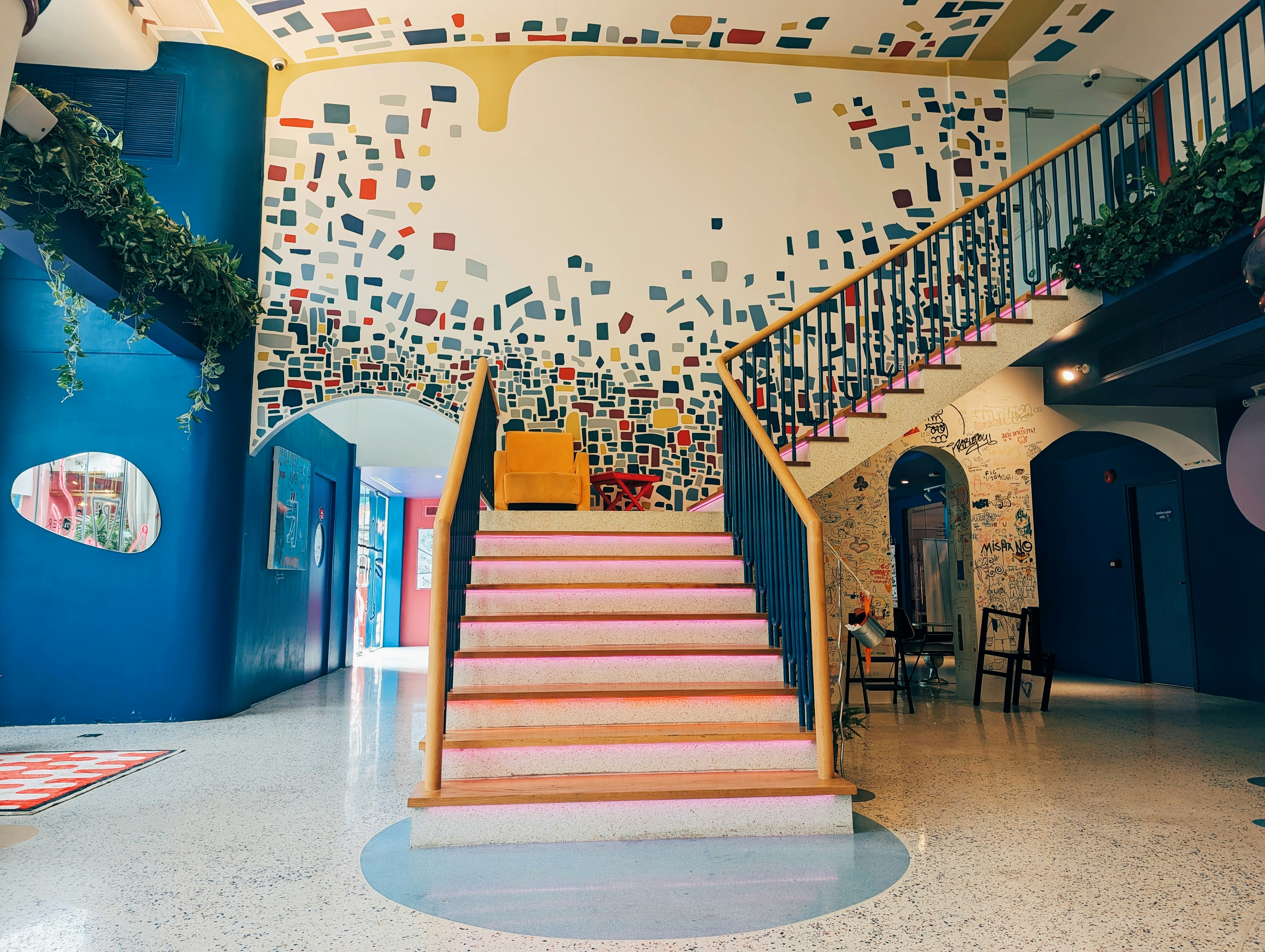 A room with a staircase and a mural on the wall