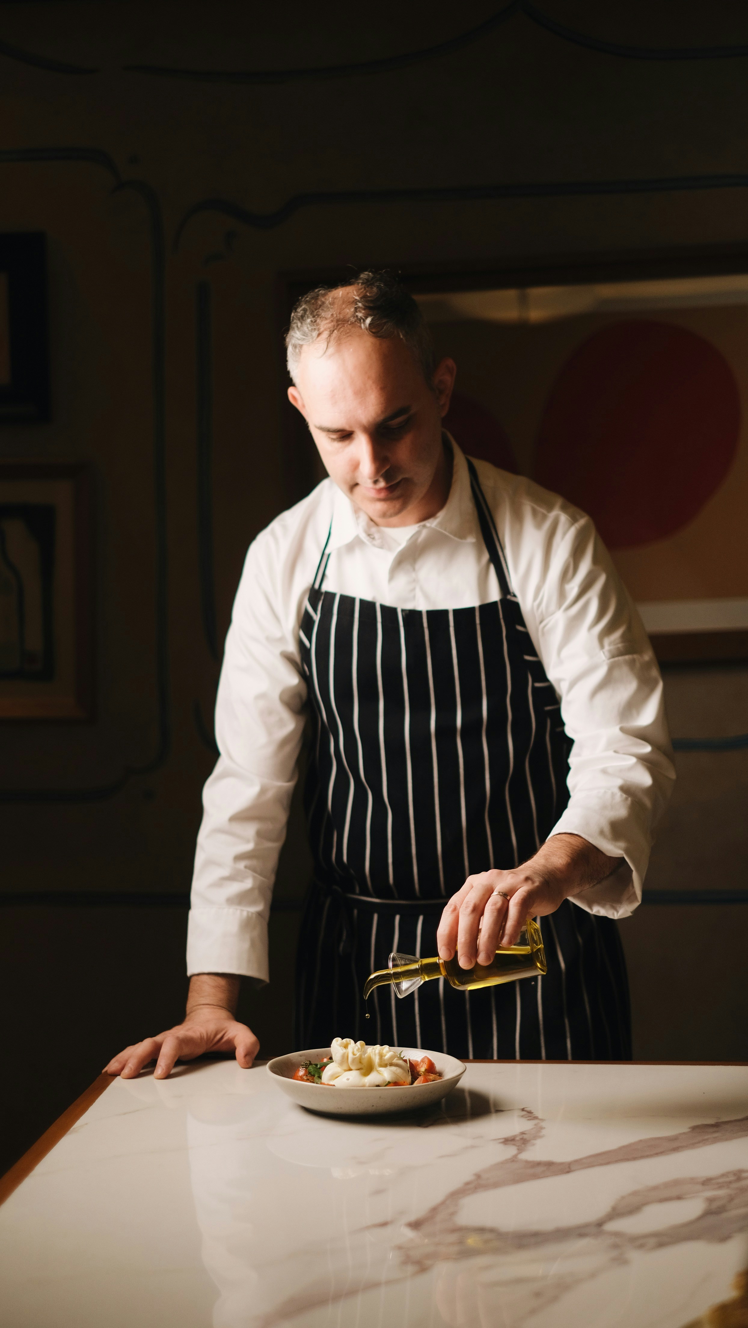 A man in an apron preparing food on a table