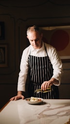A man in an apron preparing food on a table