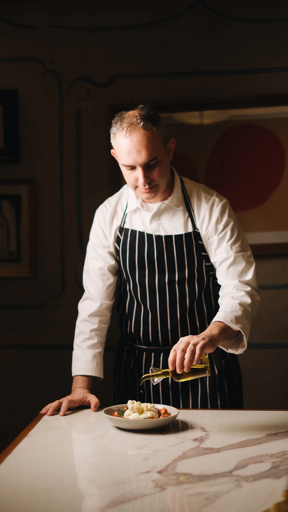 Chef in apron preparing food on a wooden table — hands at work.